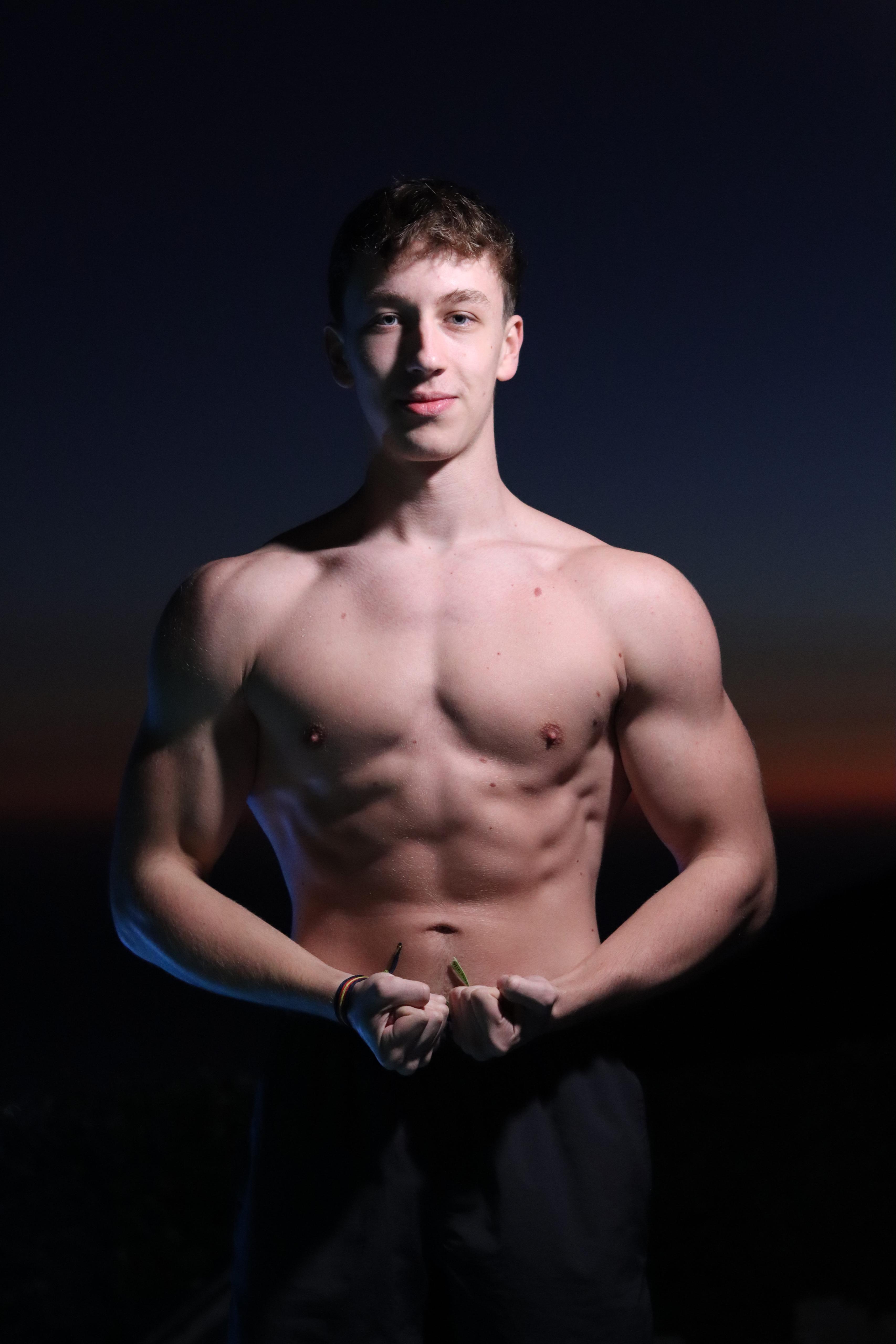 man in white tank top holding bumper plate