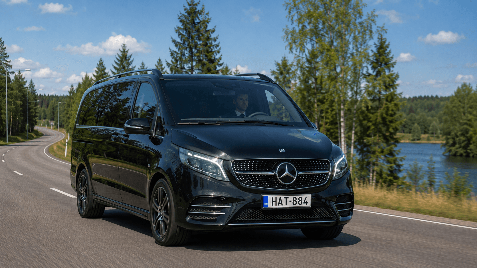 Private driver at the wheel of a black Mercedes van on a Finnish country road near Helsinki