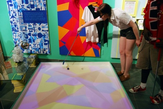 a woman trying to guid a golf ball into the hole