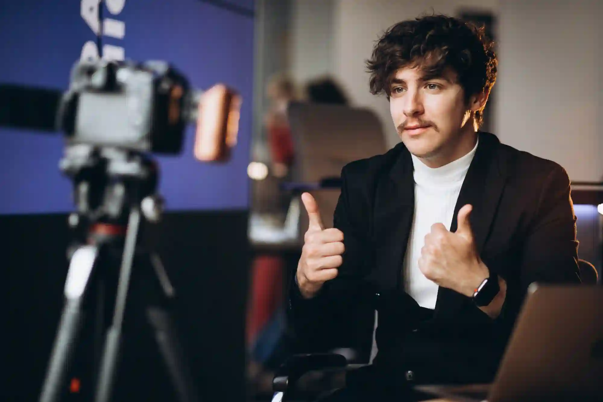 A man gives two thumbs up while filming a video, representing high-quality content creation and digital engagement.