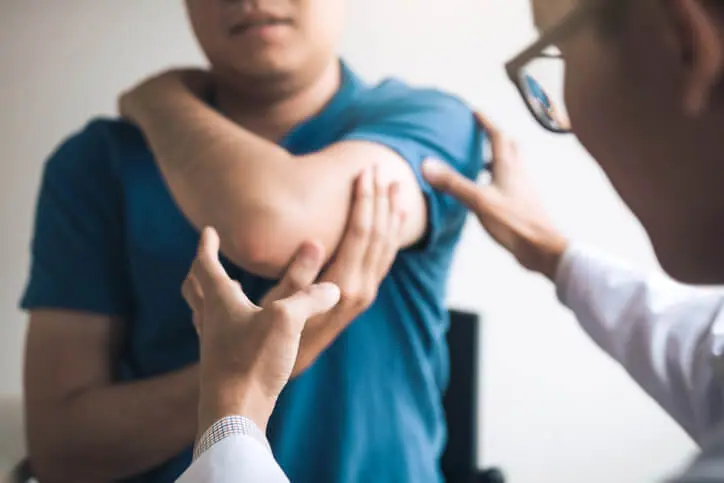Person receiving an elbow examination from a clinician