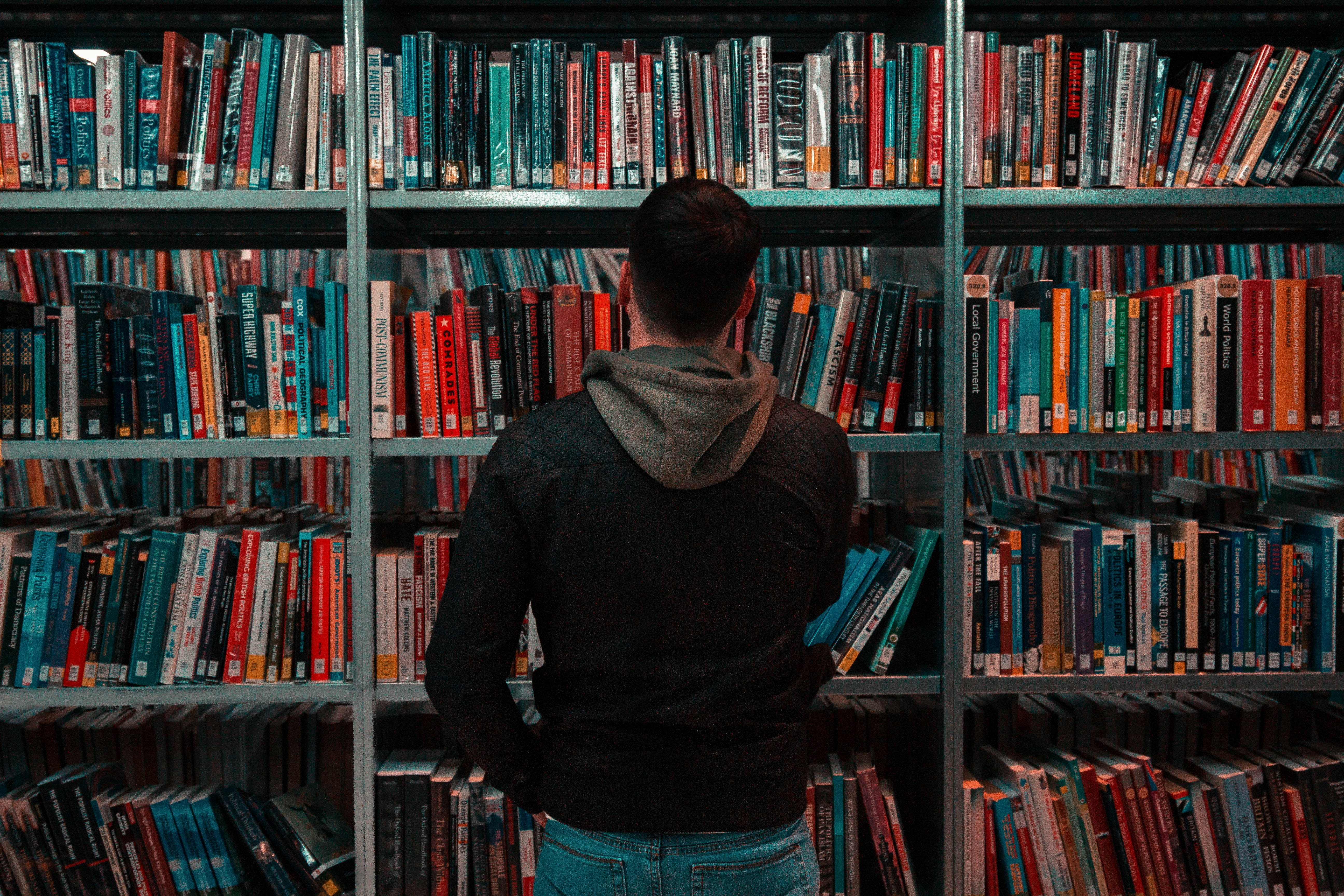 Man Standing infront of Books Rack - What Is Second Brain Studying