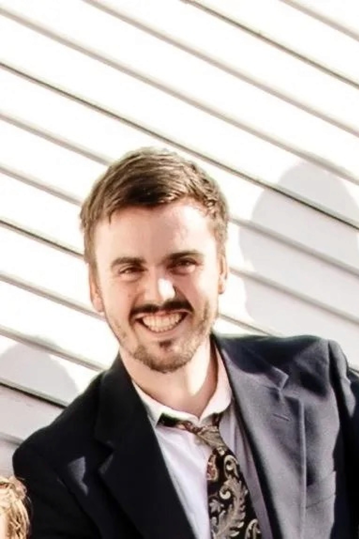A bride in a white lace wedding dress holds a colorful bouquet of pink, yellow, and orange flowers.