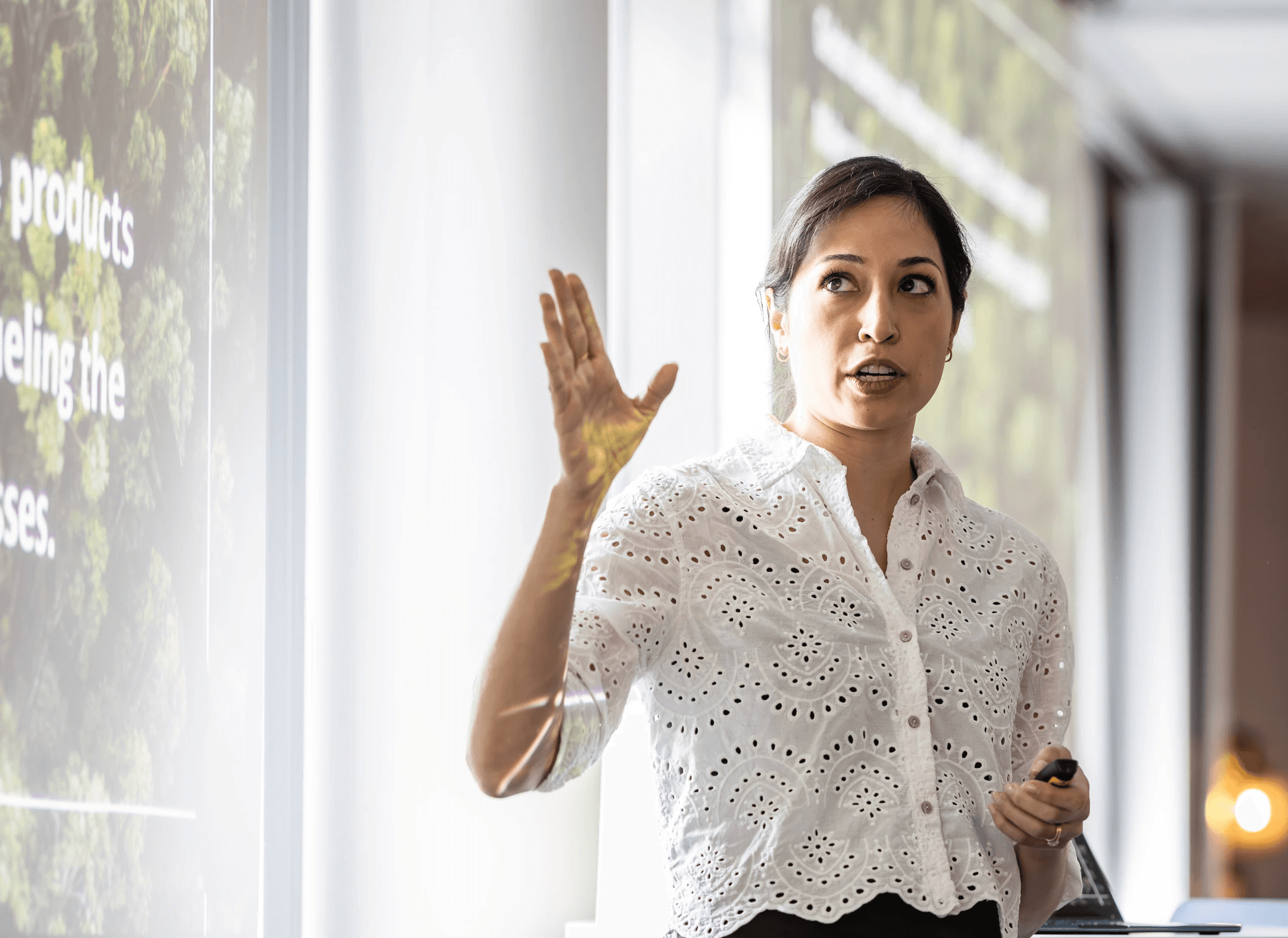 A person wearing a virtual reality headset stands in front of multiple screens, engaged in a digital experience.