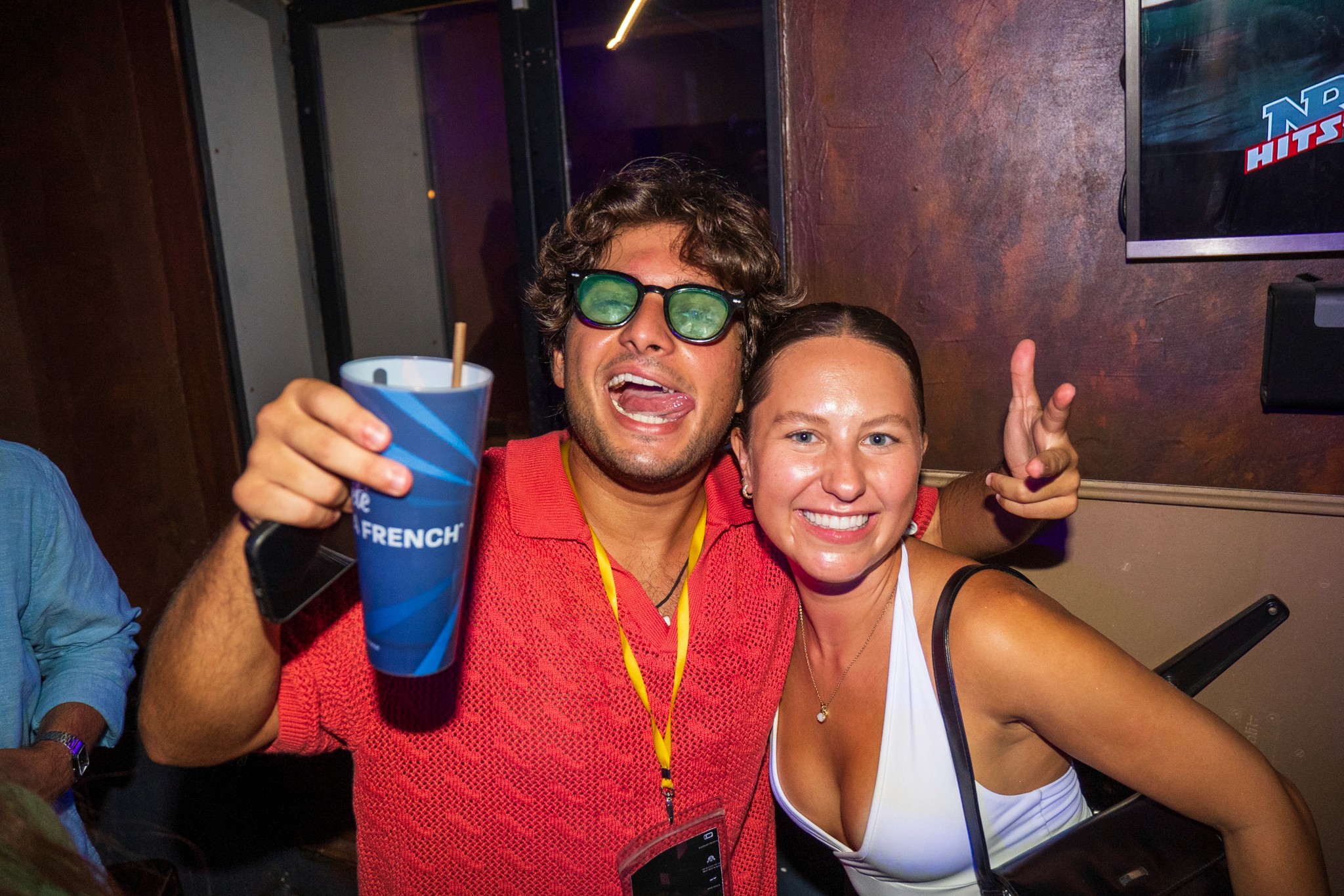 Young man and woman celebrating together during a bar crawl in Nice holding drinks and smiling capturing loud party energy strong social vibes and the festive nightlife atmosphere of the French Riviera