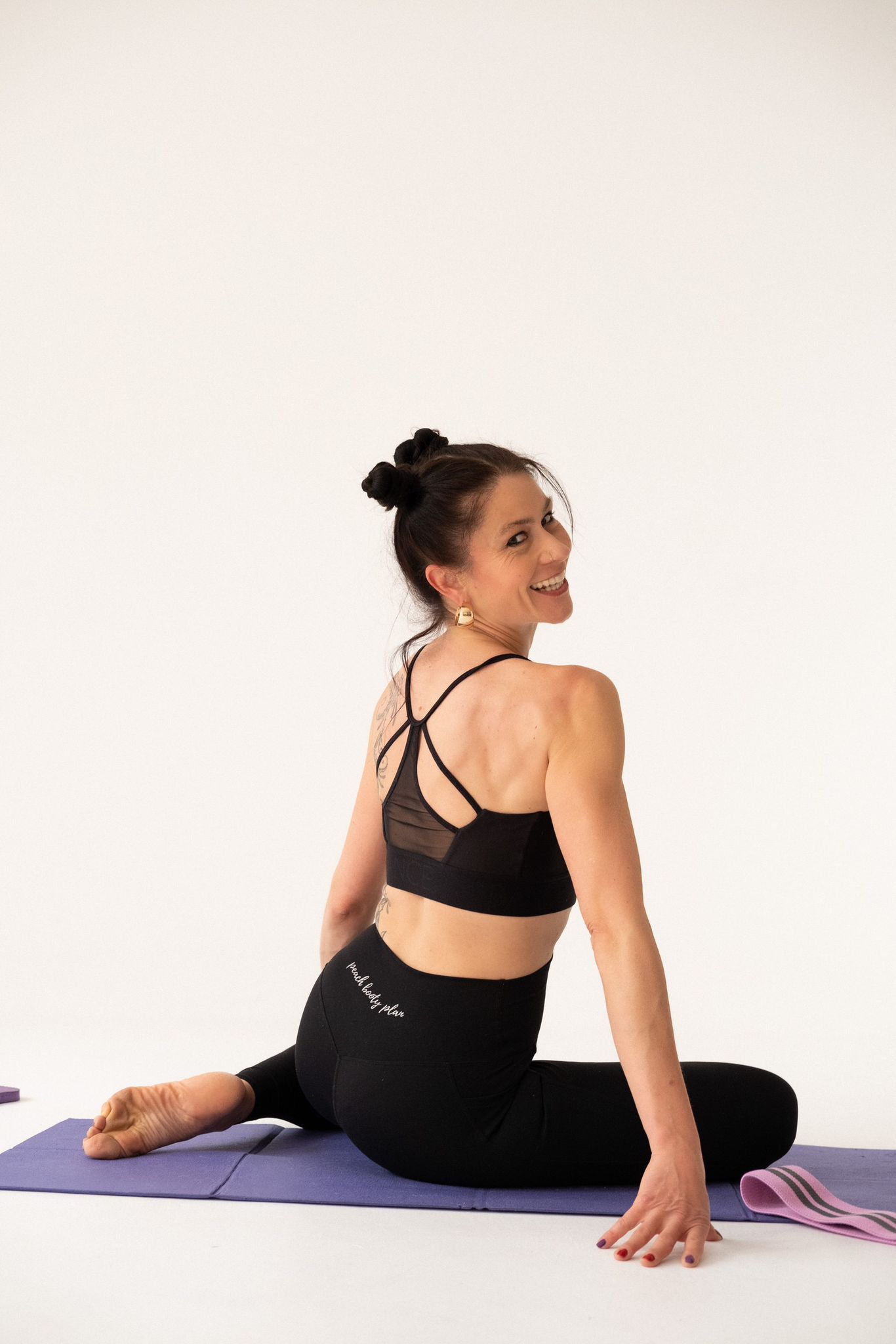 a woman in a leotard jumpsuit doing a yoga pose