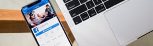 phone with Facebook open next to laptop