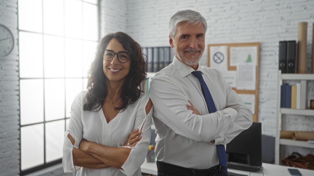 Deux professionnels confiants dans un bureau, illustrant les avantages de détenir une assurance vie au nom d'une entreprise.