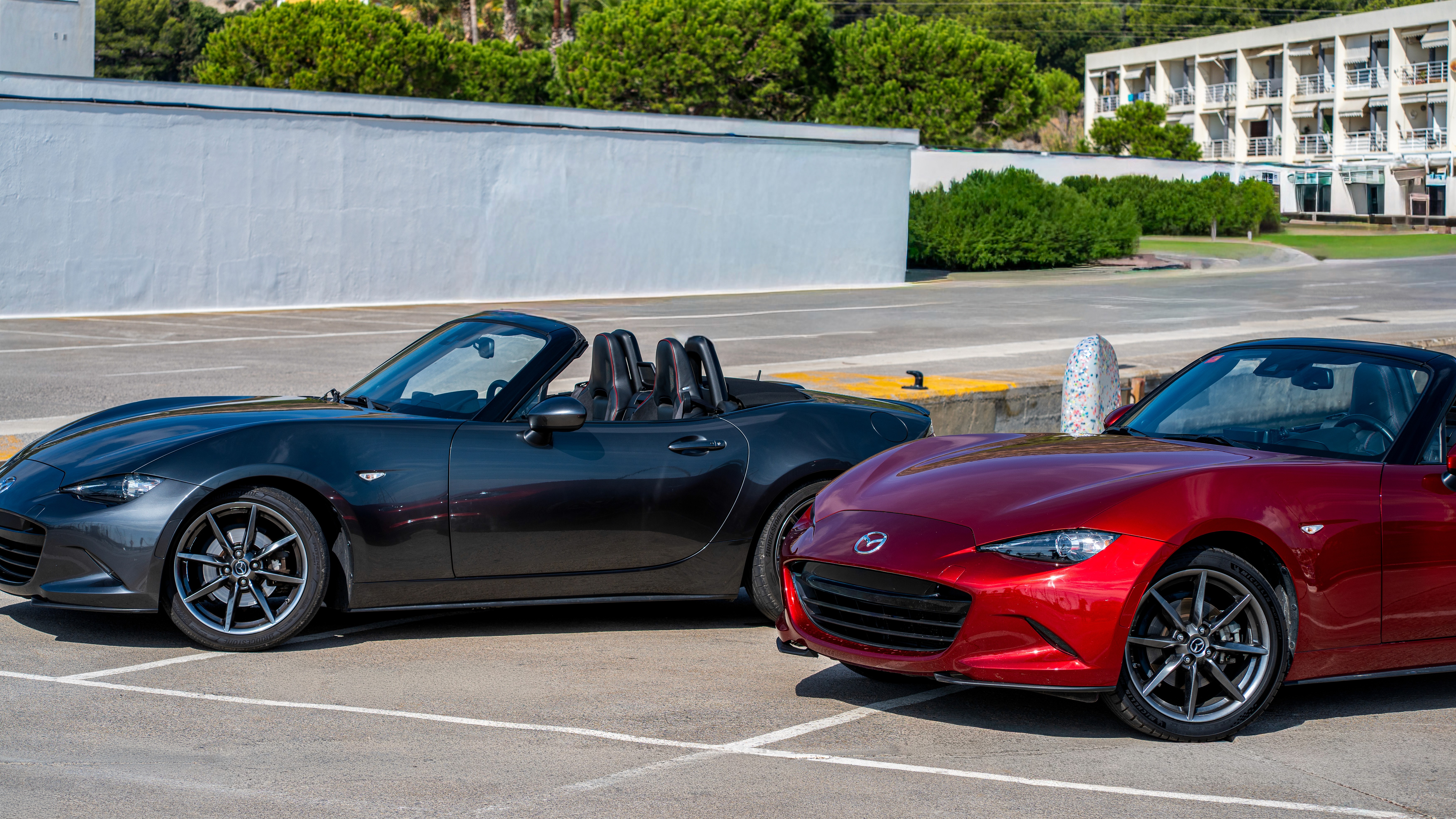 Two cheerful men laughing in the front seats of a sportscar, great for car rental joy promotions.