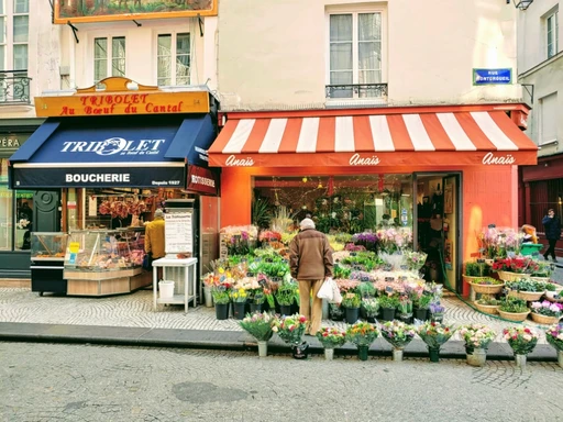 Flower shop and butcher on Rue Montorgueil in Paris, a typical French street market scene