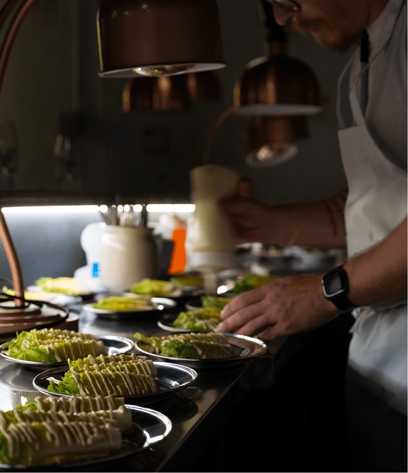 Un cuisinier prépare les entrées de salades césar.