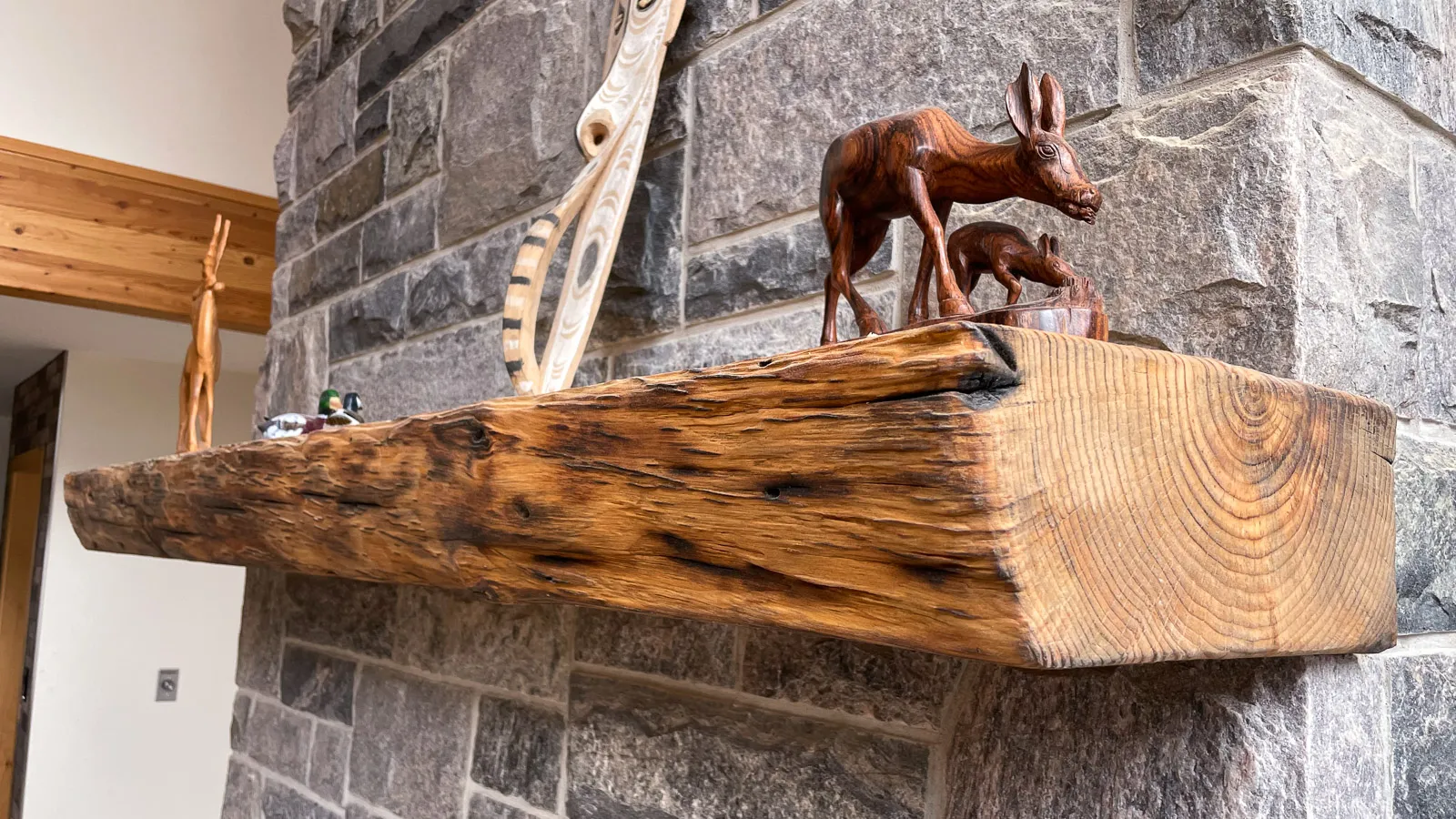 Hand built burn-brushed wood mantle built in to granite chimney.