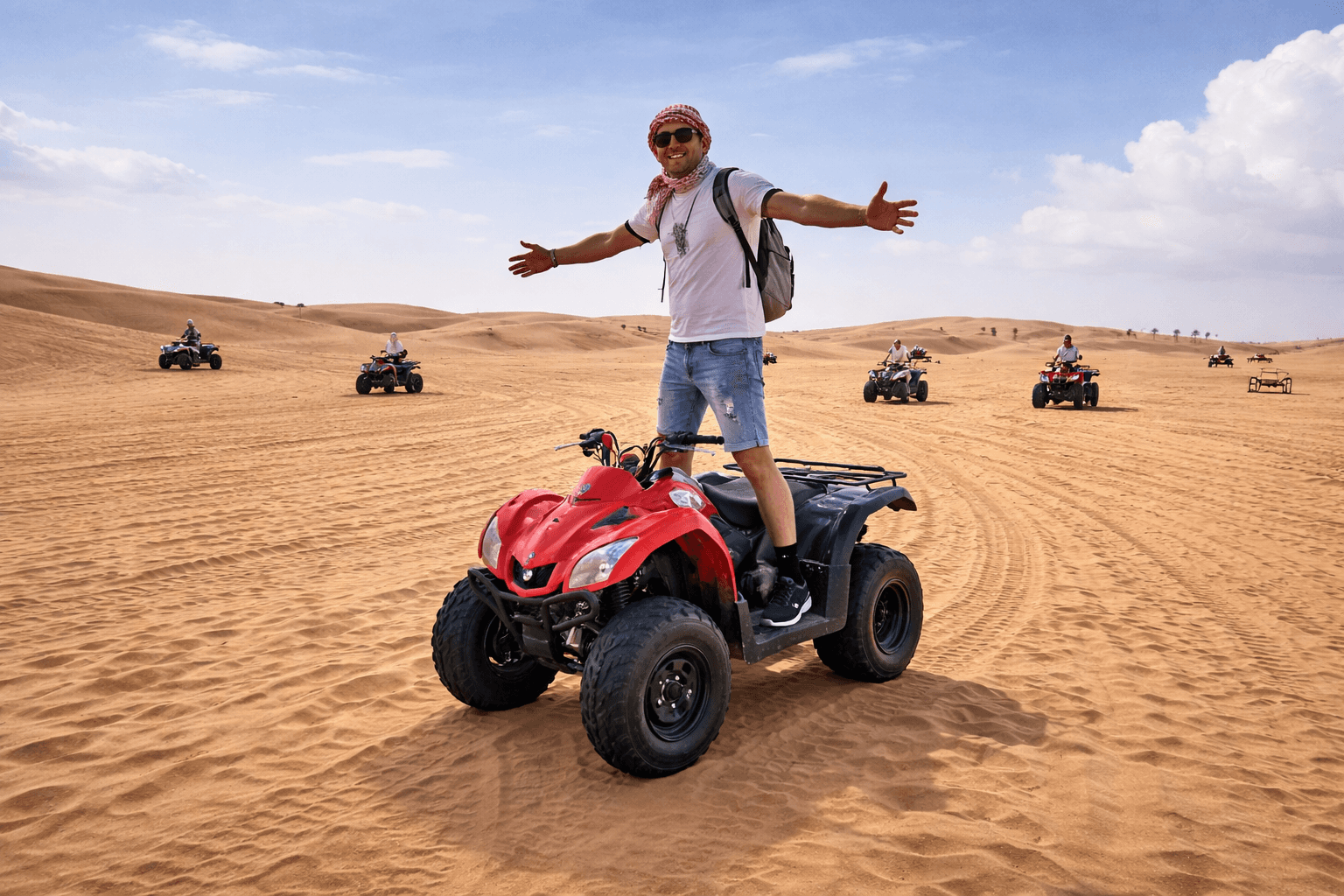 ourist standing on an ATV quad bike during a Dubai desert safari experience with Dune Quest Tours