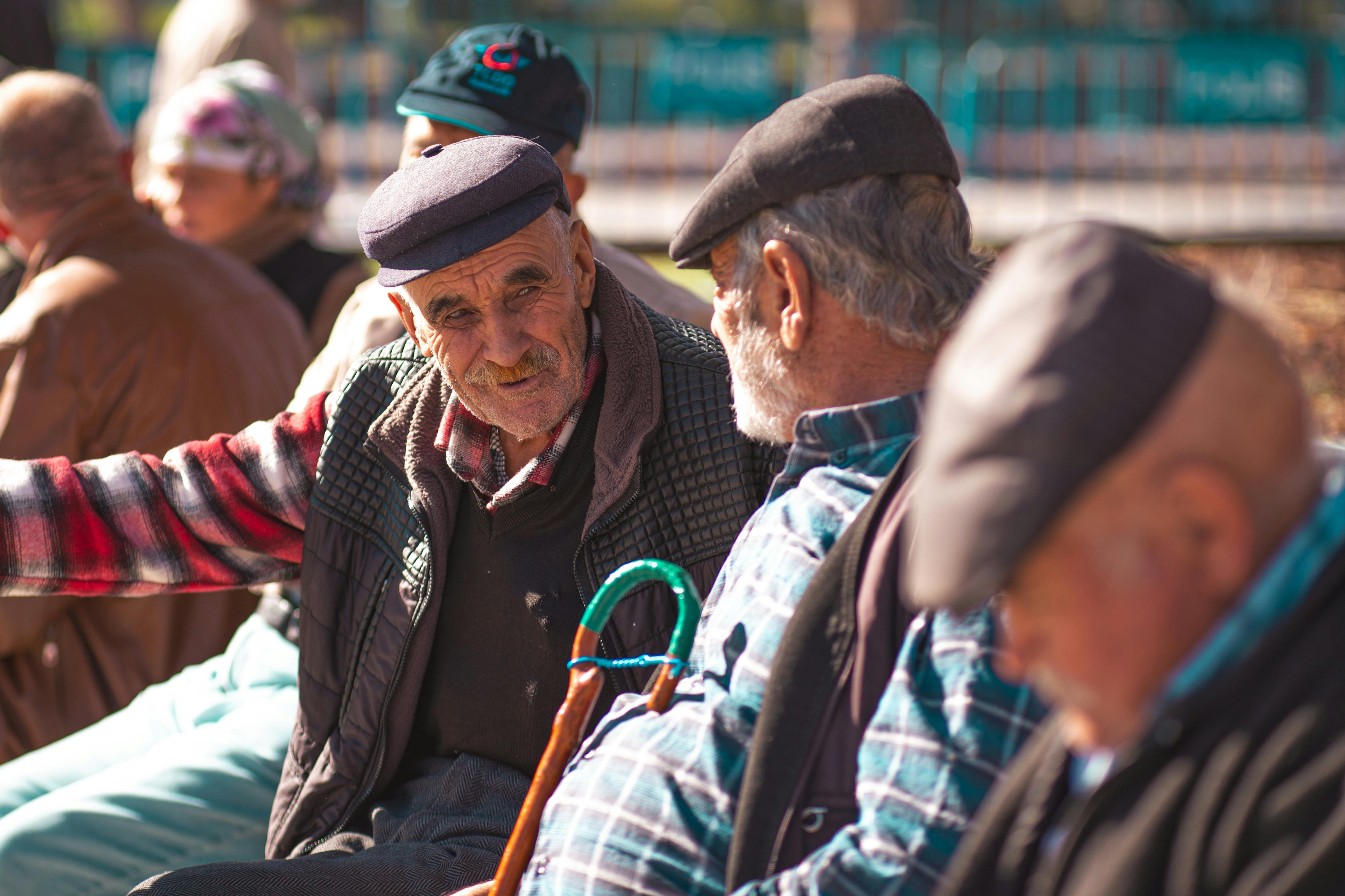Elderly man chatting happily with carer during outdoor visit.