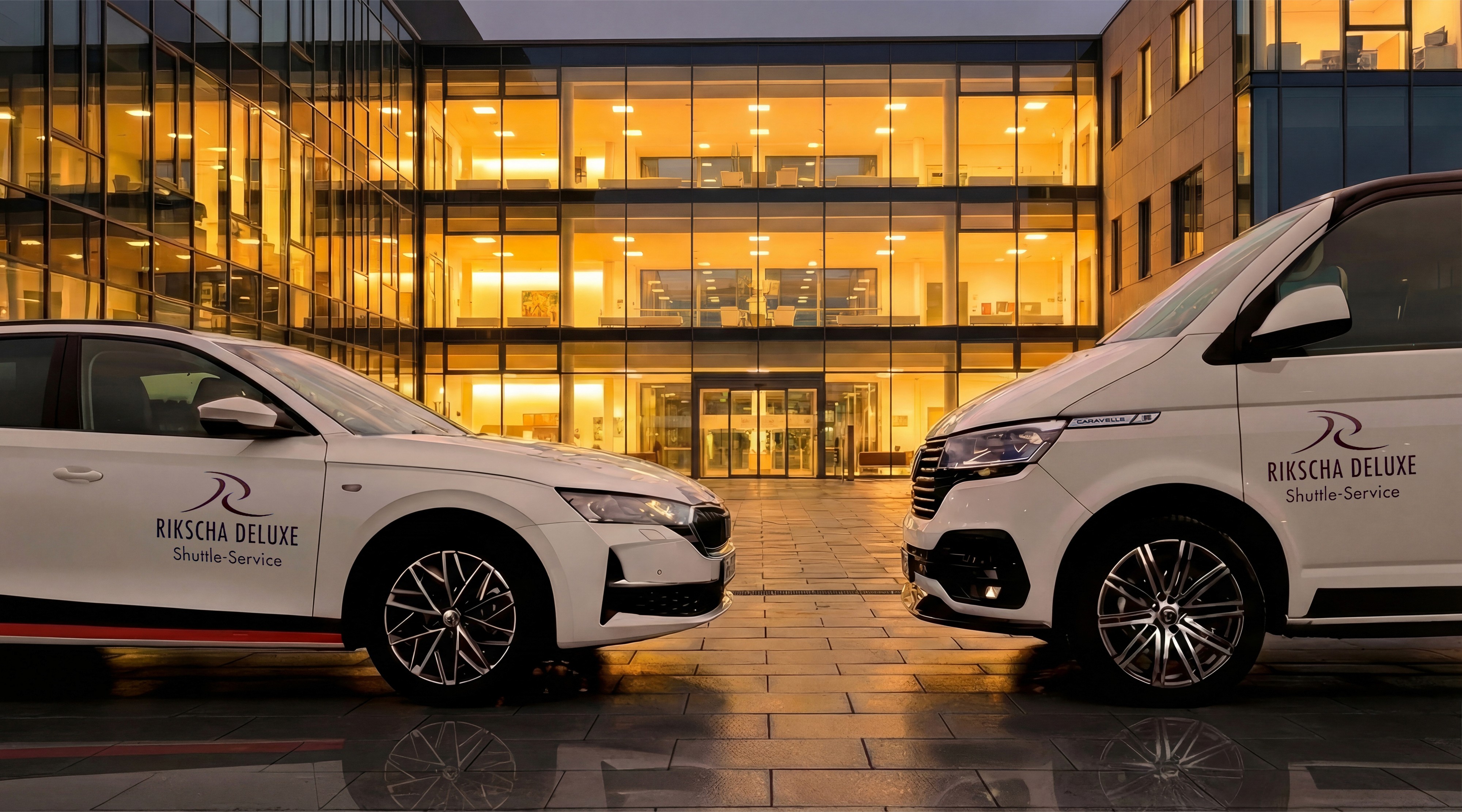 Zwei weiße Servicefahrzeuge der Firma Rikscha Deluxe parken vor einem modernen Krankenhaus mit beleuchteten Fenstern