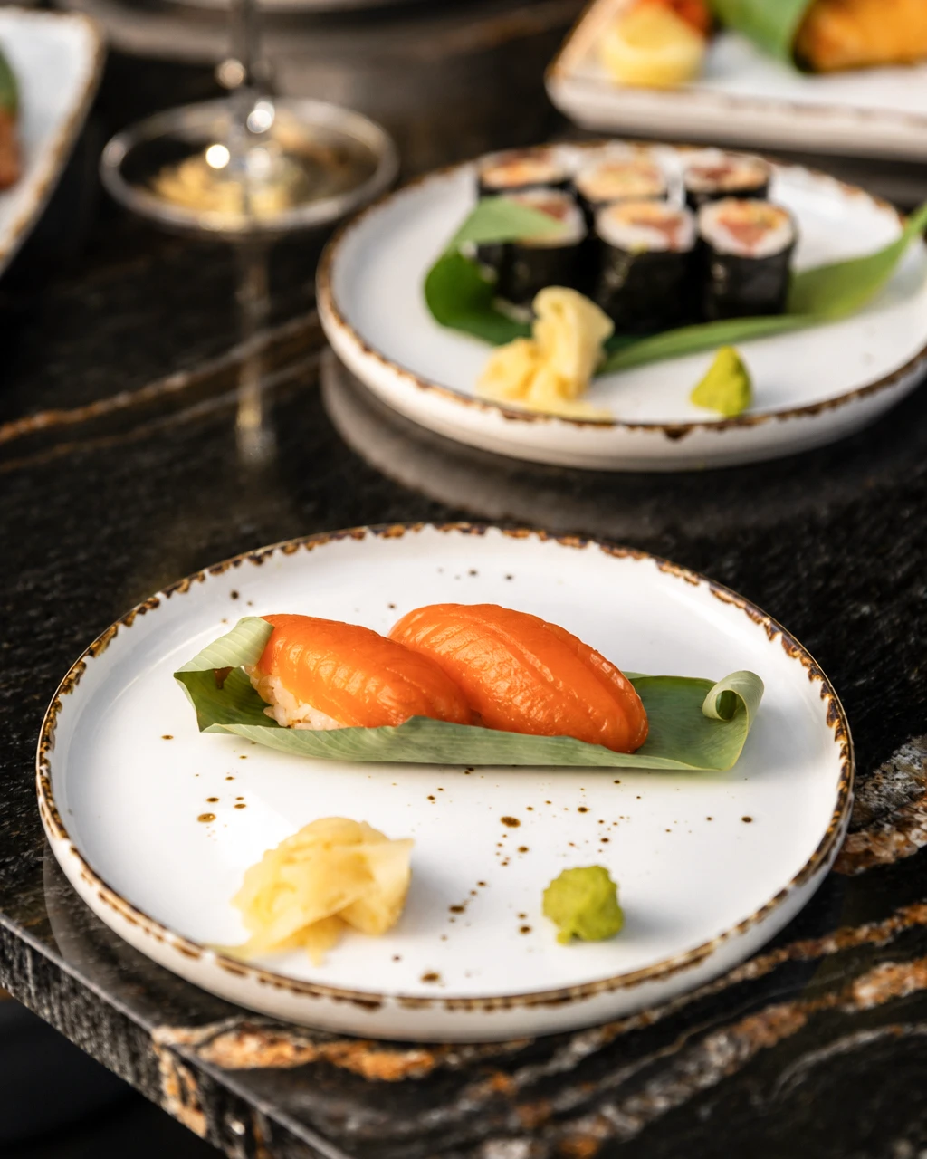 Salmon nigiri, sushi rolls, ginger, and wasabi.