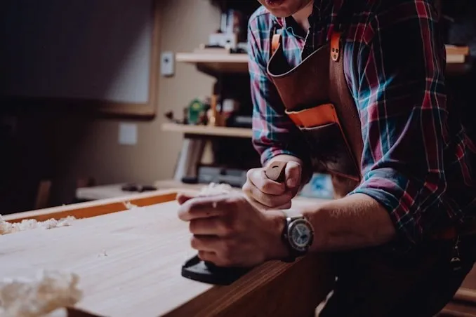 Artisan travaillant le bois dans son atelier.