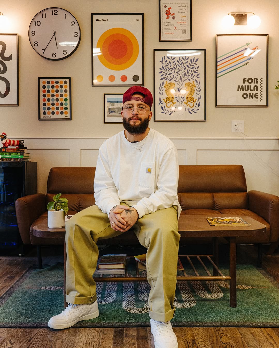 Mac wearing a white long sleeve and backwards hat sitting in the shop's waiting area