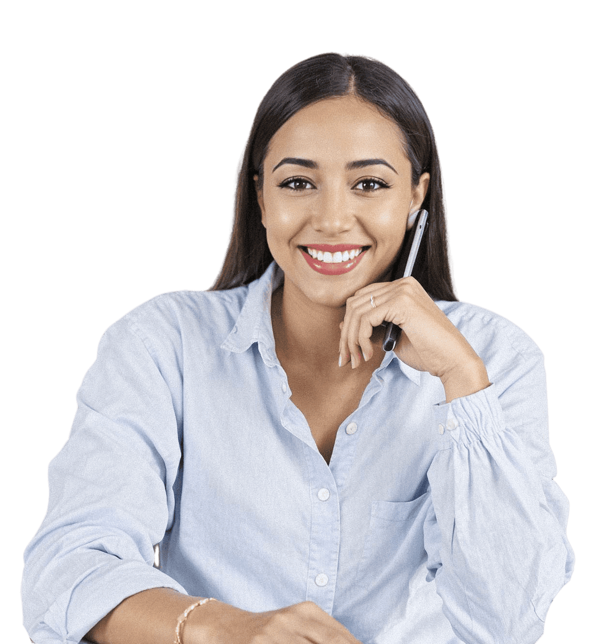 A smiling woman with long dark hair, wearing a light blue shirt, rests her chin on her hand, looking at the camera.