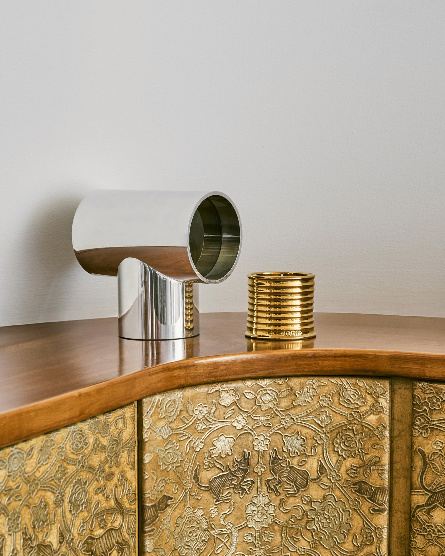 Gold LOEWE scented candle styled beside a chrome table lamp inside Antonio Lamela’s modernist Madrid studio.