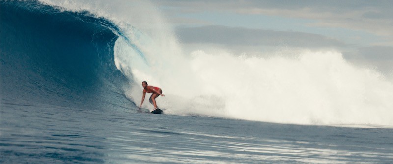 Girl surfing a massive wave in indonesia