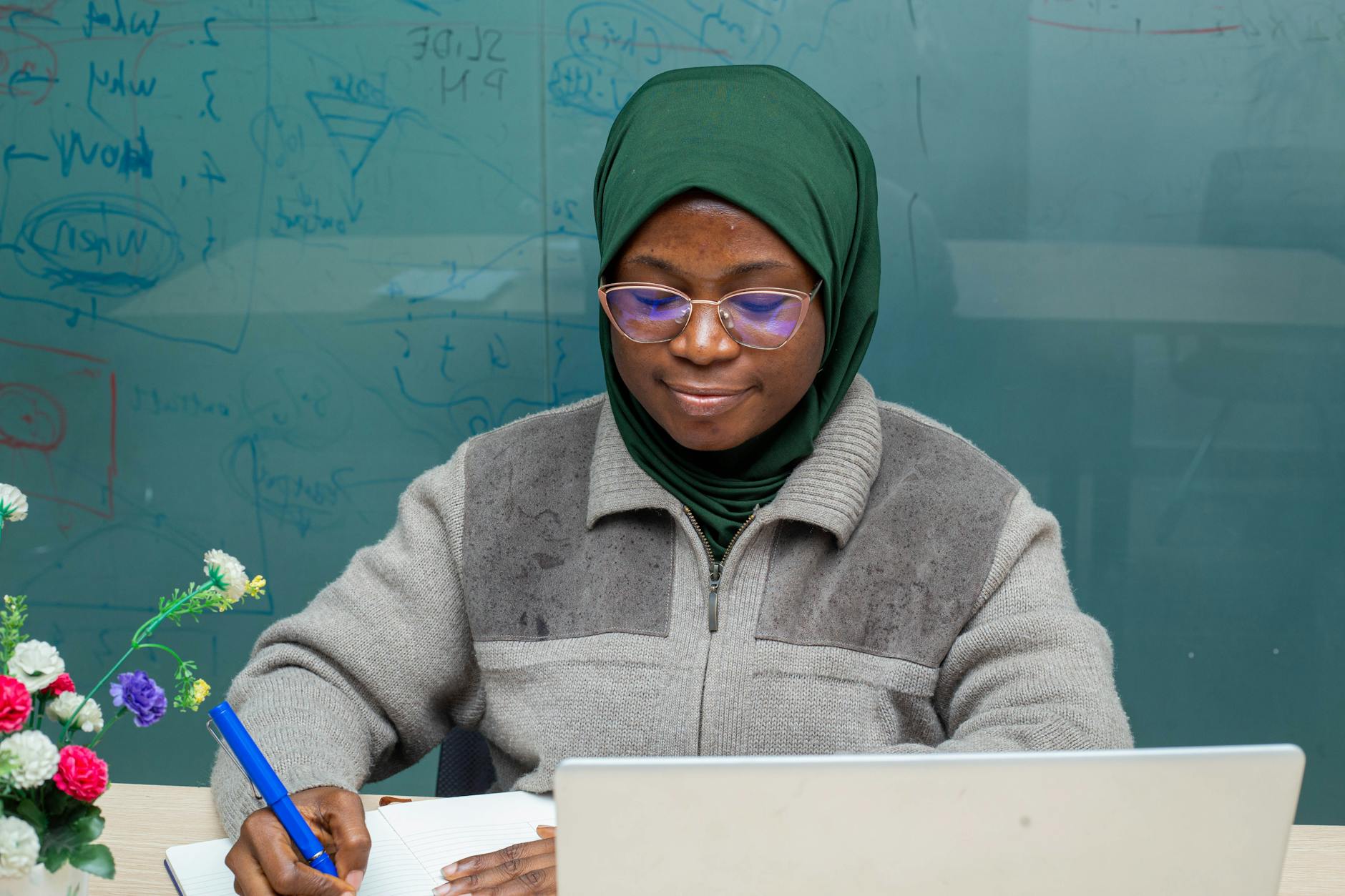 A teacher wearing a headset while looking at a computer monitor to resolve Savvas Realize login errors.