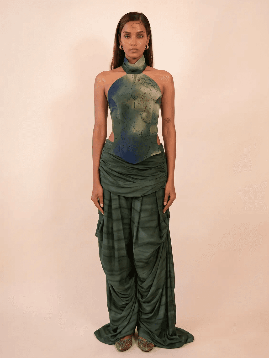 They feature asymmetrical tucks and fluid folds pinned at varying levels,
