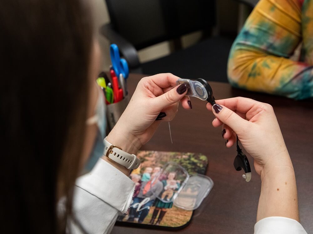 Man sitting in a testing booth having a hearing test