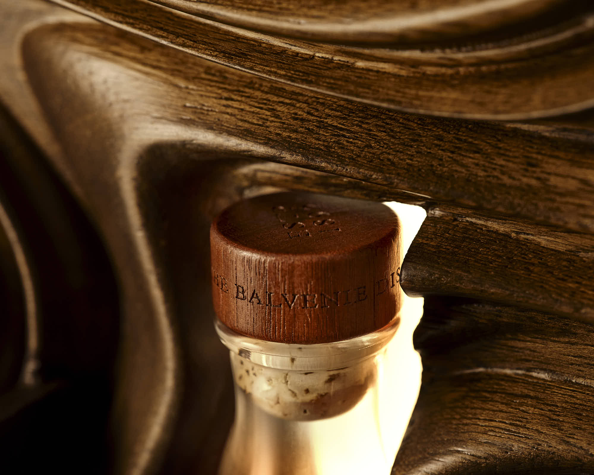 A close-up of whiskey stopper set into a wavy wood surfac