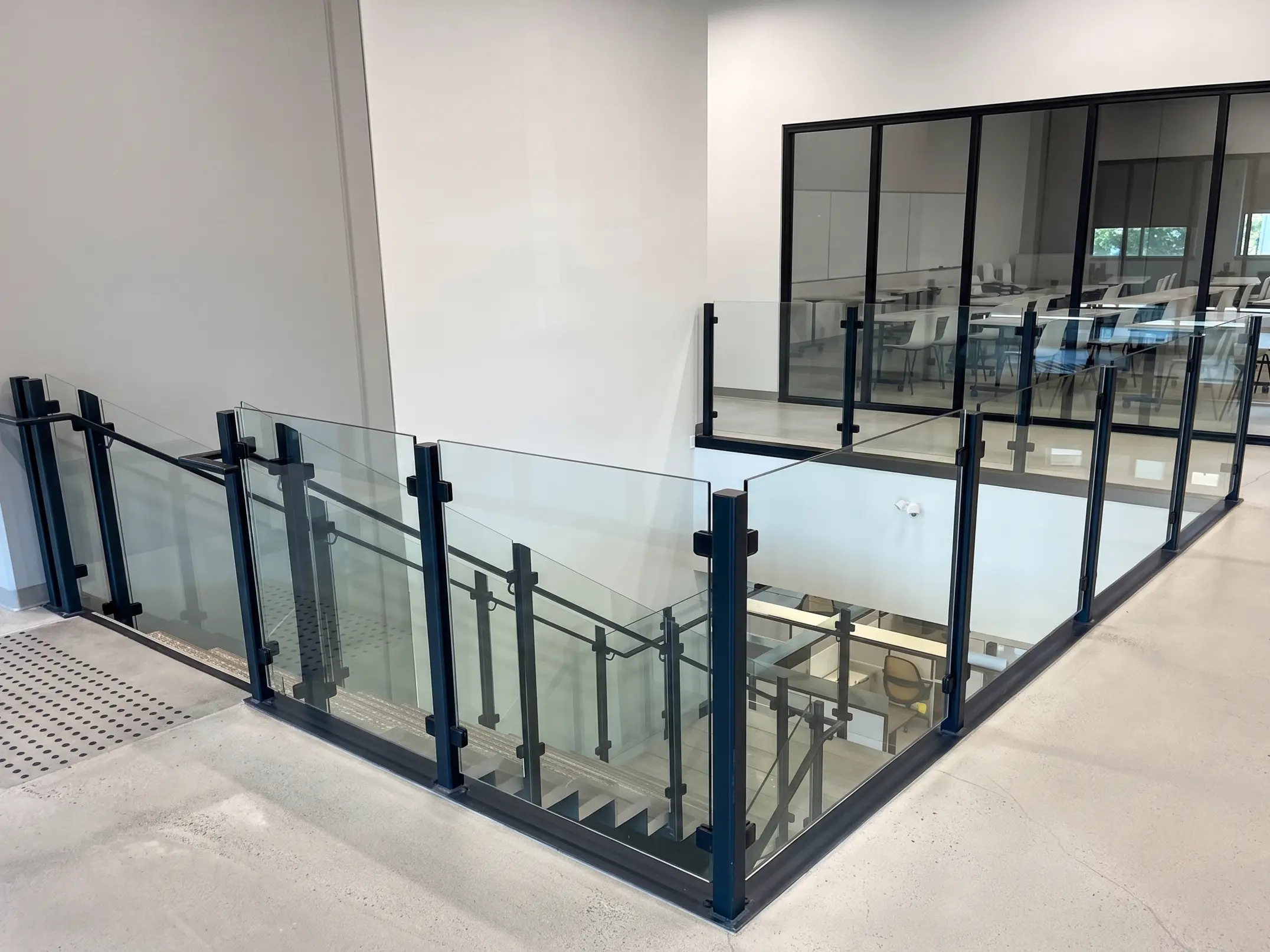 Semi-frameless glass railings with black aluminum posts inside a modern Vancouver Island home