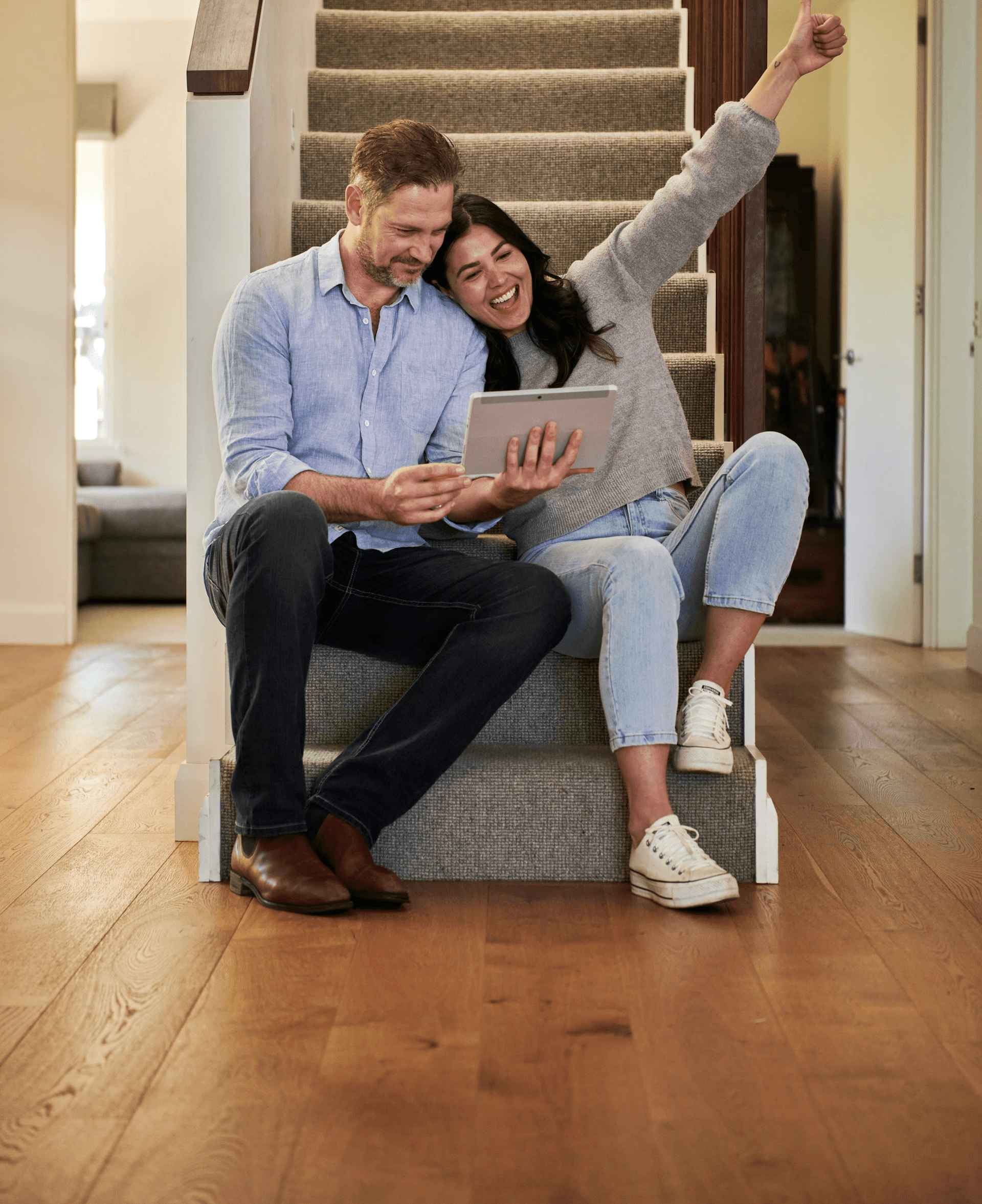 woman holding a phone and man looking at the phone. both are smiling