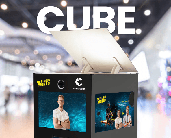 SnapCube CUBE Fotomodul auf einer Messe mit unscharfem Event-Hintergrund und gebrandeten Bildschirmvisuals.