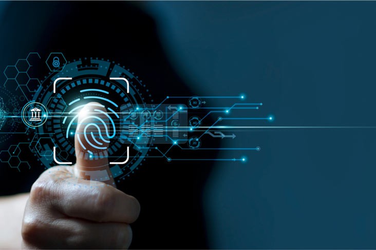 A person walks in front of large stone arches with dark doors, flanked by tall columns, in a historic building.