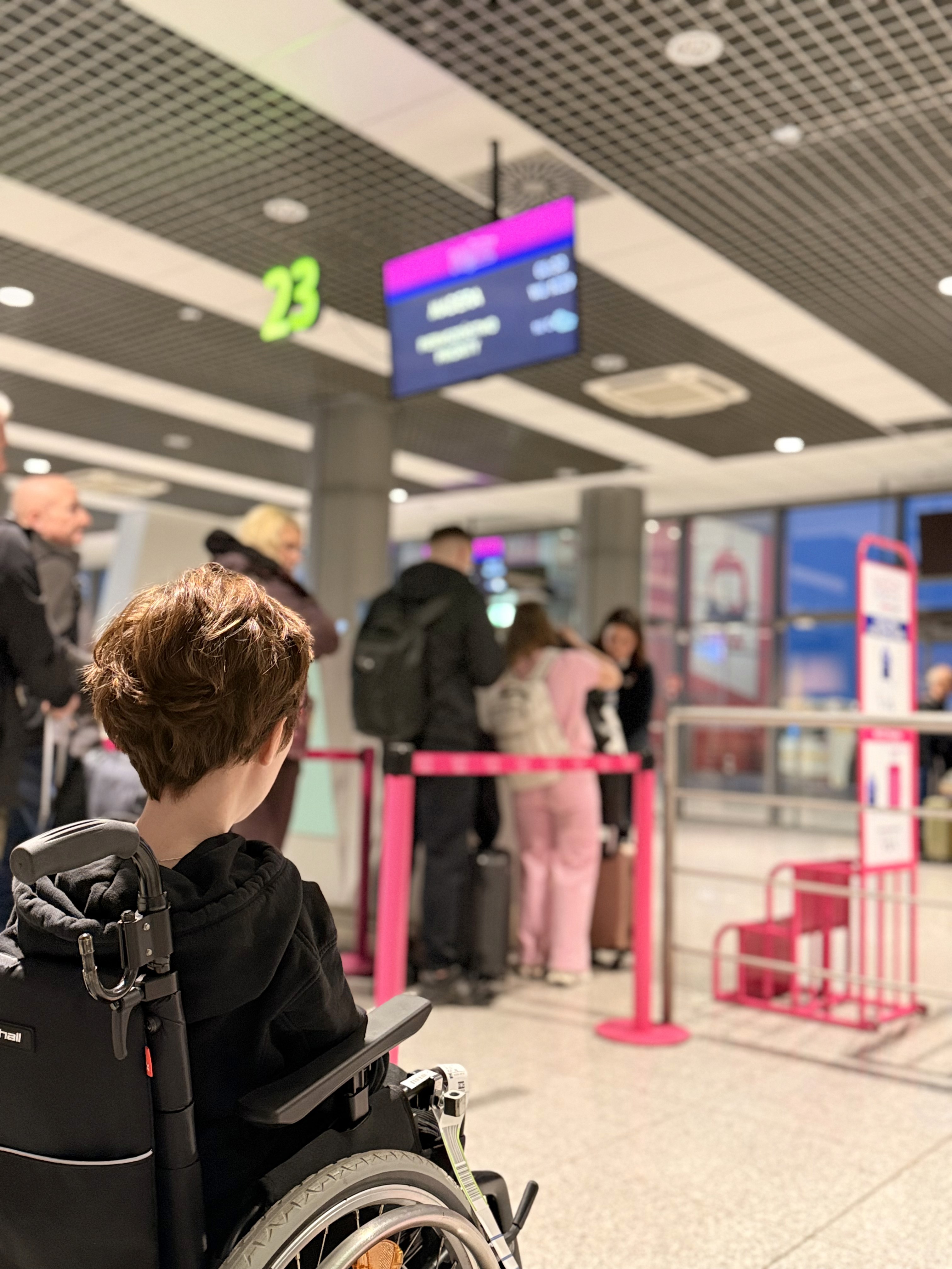A man wearing sunglasses and a t-shirt stands against blue.