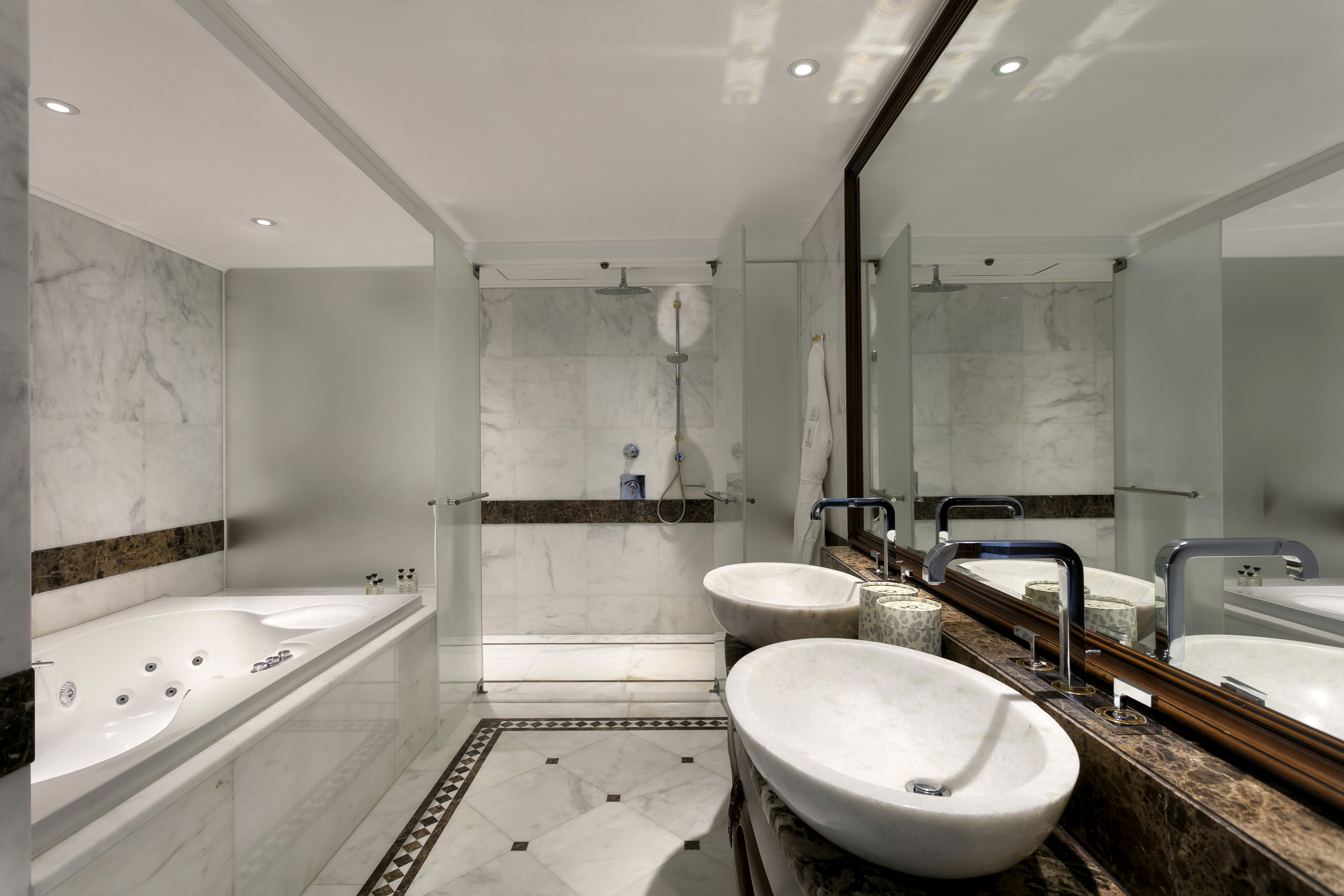 Jacuzzi bathroom with shower, branded amenities, and a refined design.