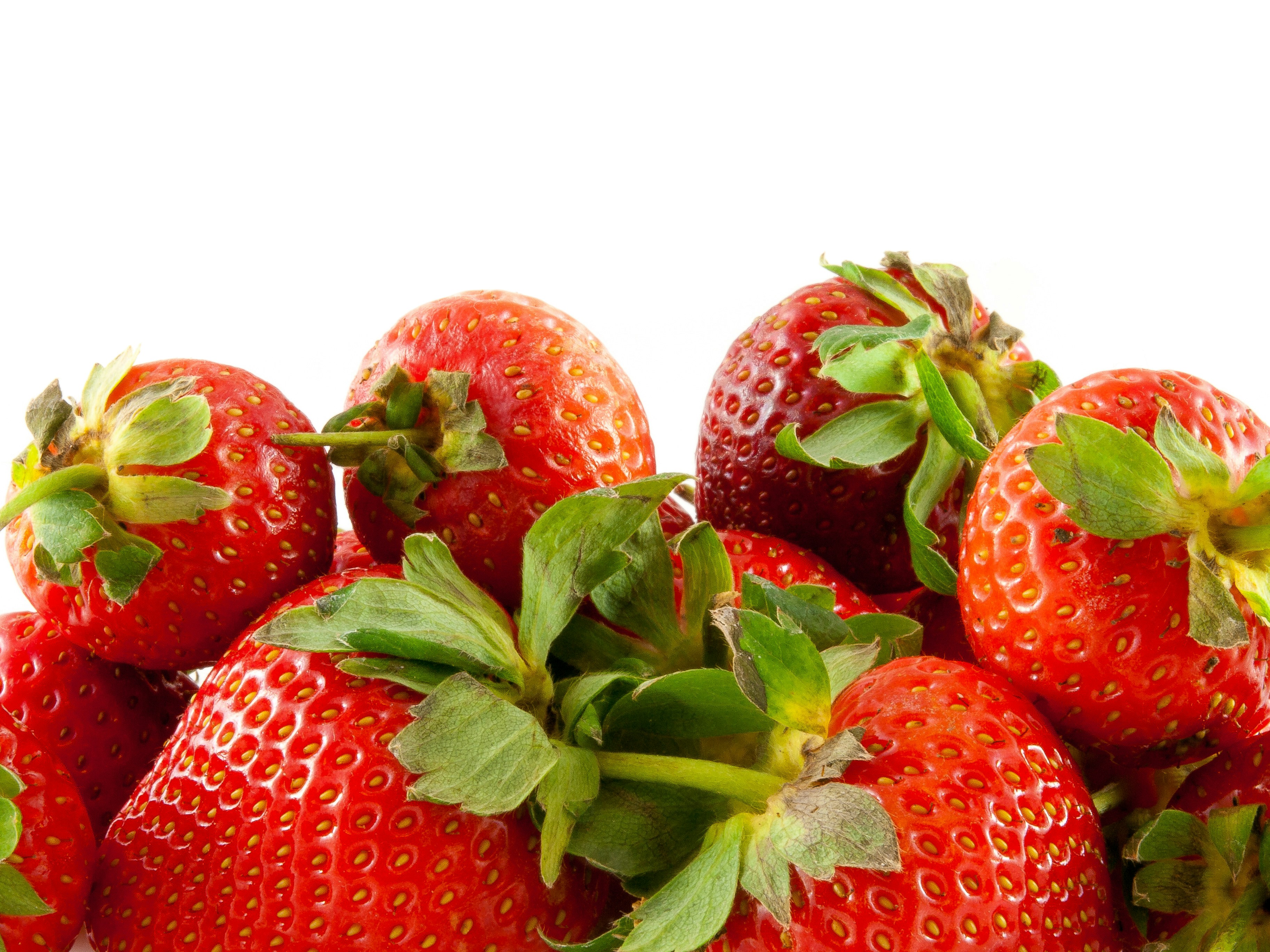 a group of strawberries with leaves on a white background