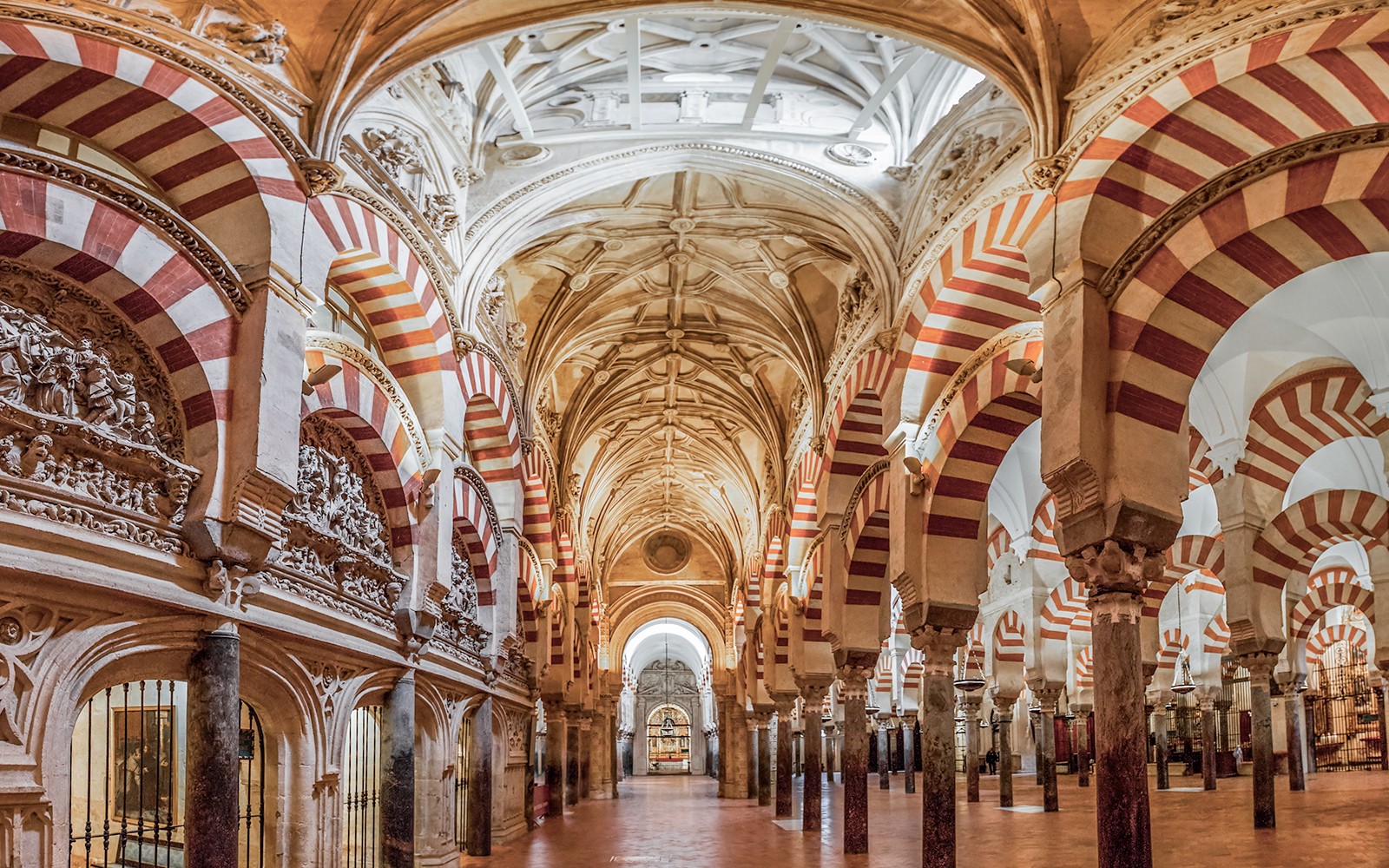 Innenansicht der Gebetshalle der Moschee-Kathedrale von Cordoba mit roten und weißen Bögen.