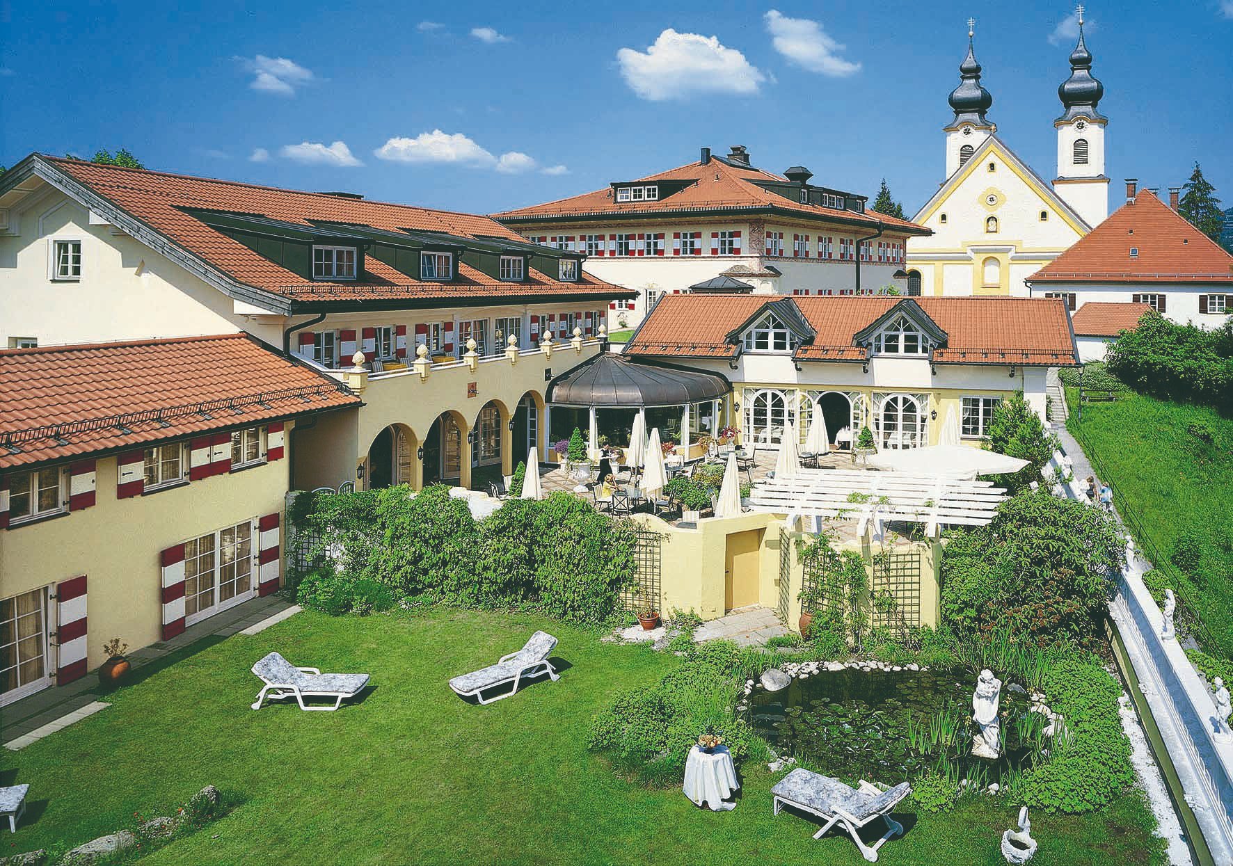 Außenansicht Residenz Heinz Winkler mit Terrasse und Garten.