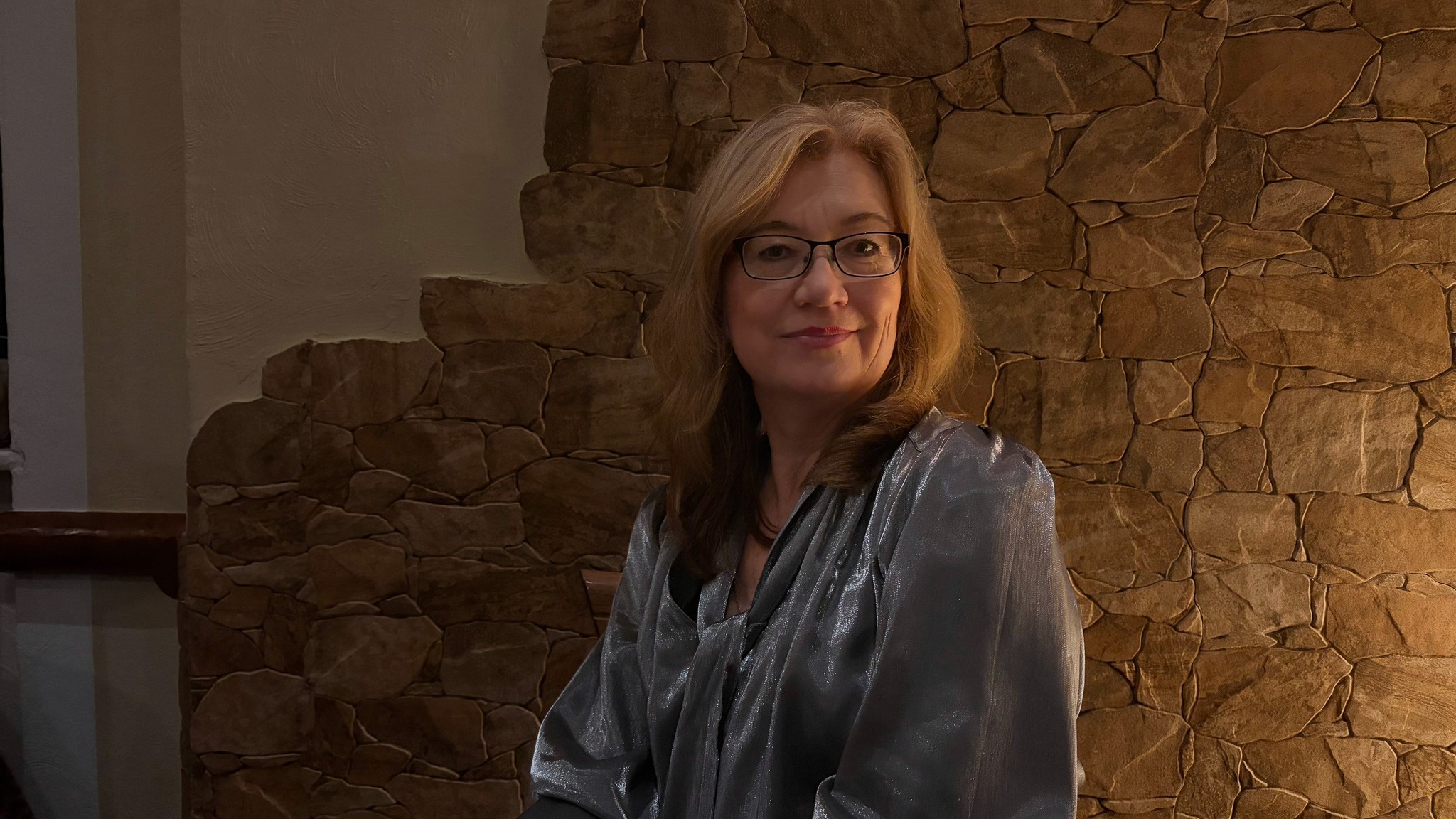 woman in blue tank top standing beside white wall
