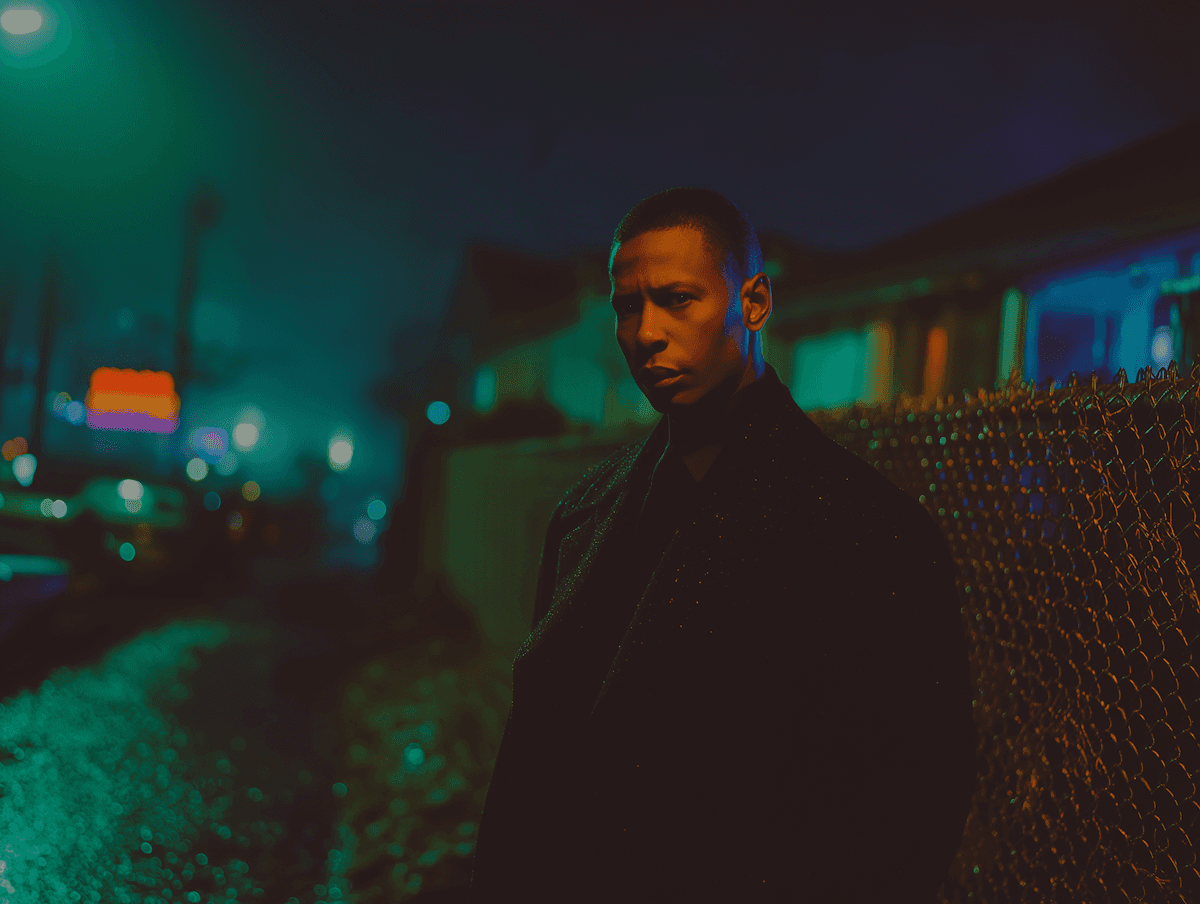 A person's face seen through a dark, vertical metal grate or fence under moody lighting.