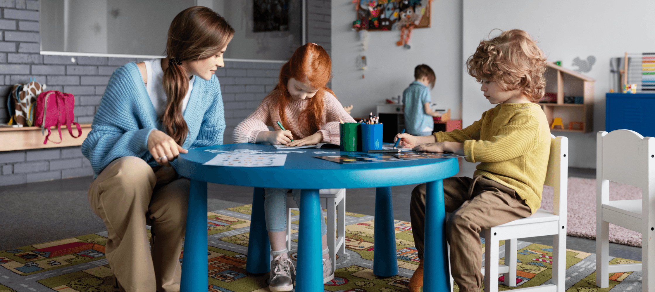 Teacher helping two children that are painting.
