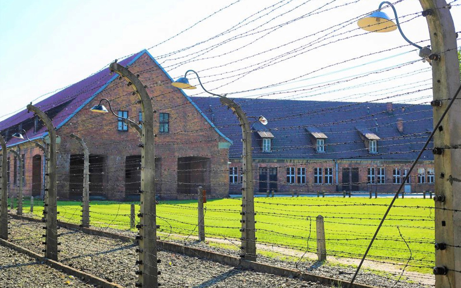 Bygging safnsins í Auschwitz-Birkenau aftan við gaddavírsgirðingu.