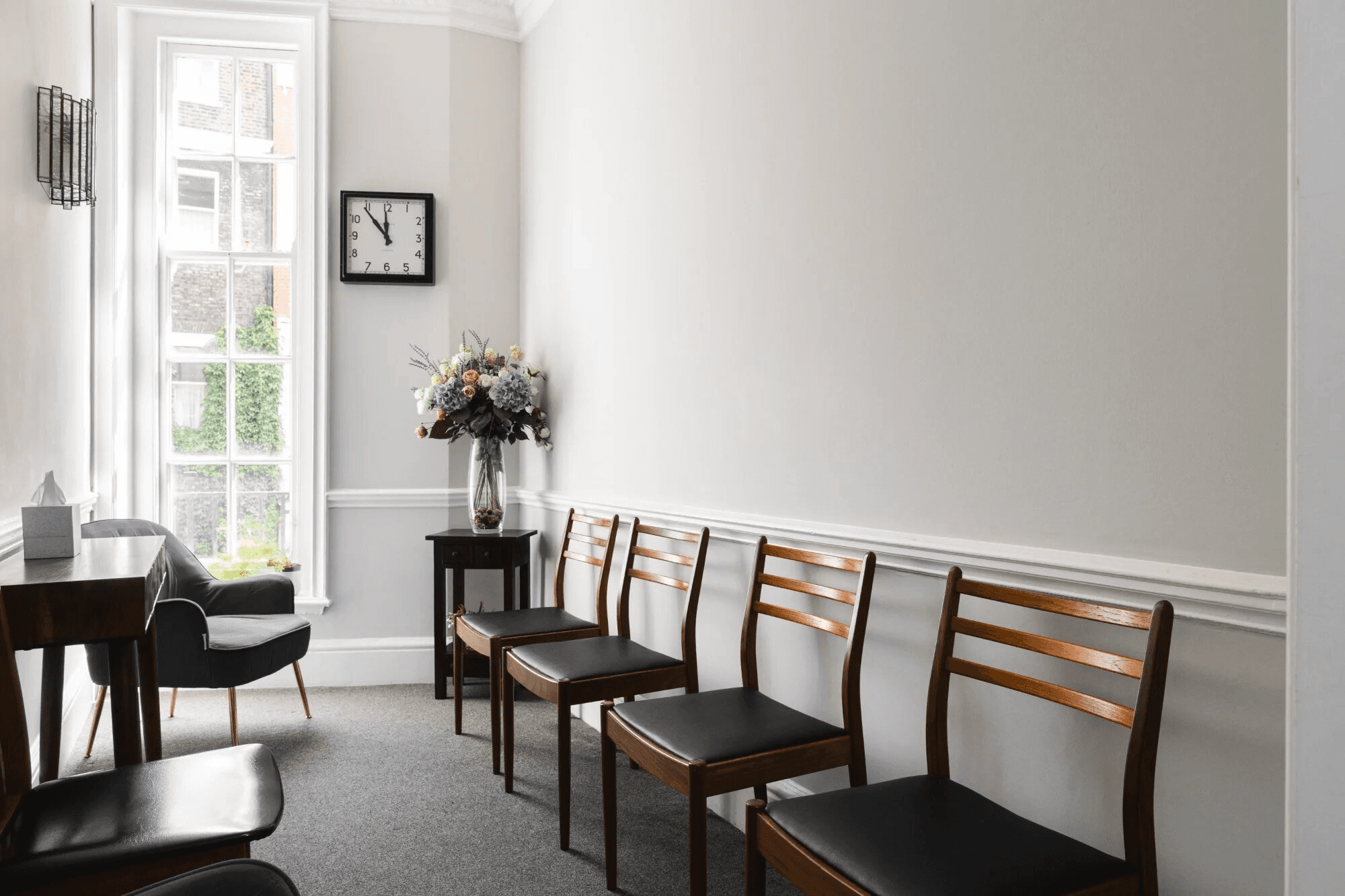 village near cliff and body of water under white clouds