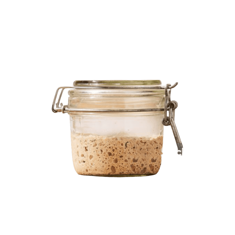 Glass jar containing sourdough starter with visible fermentation bubbles