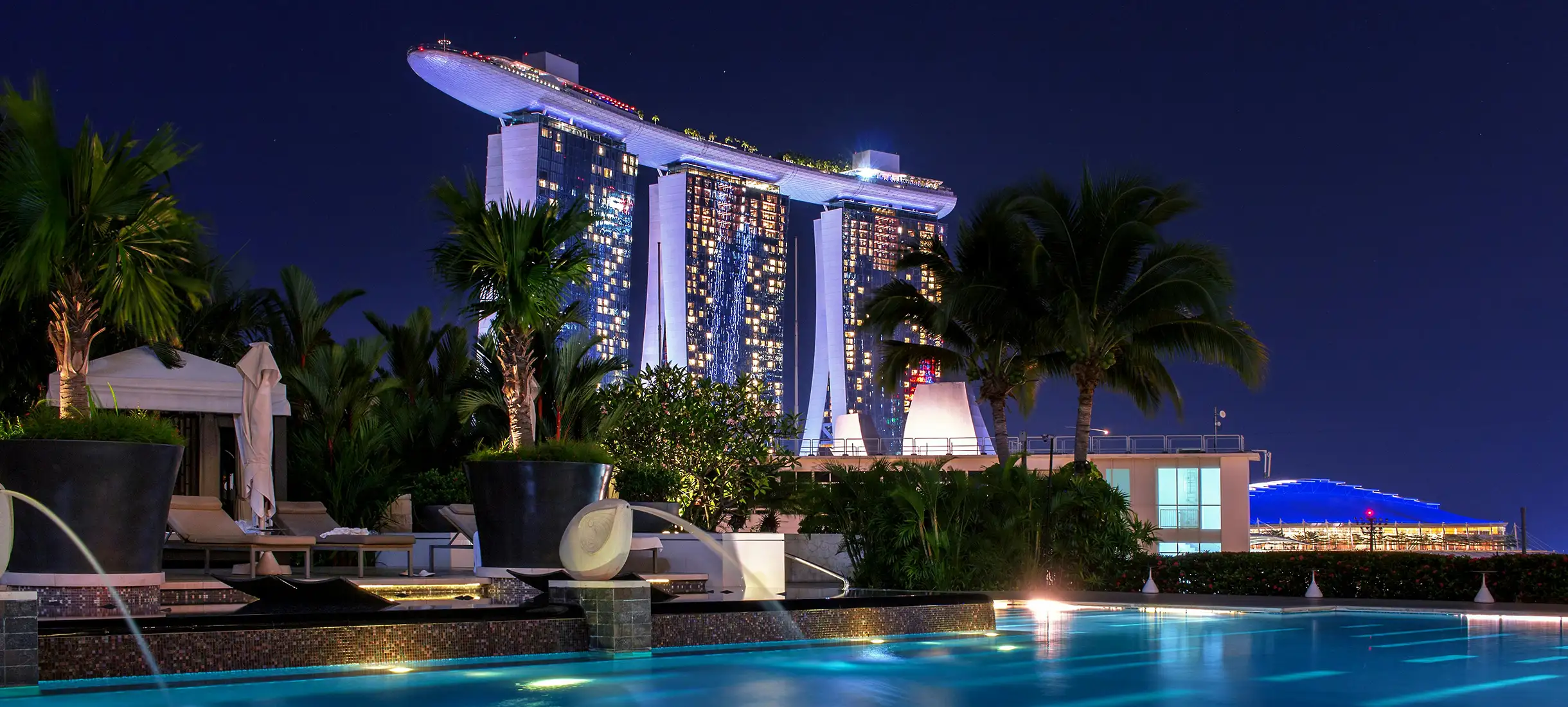Night view of Dubai city with illuminated towers and water