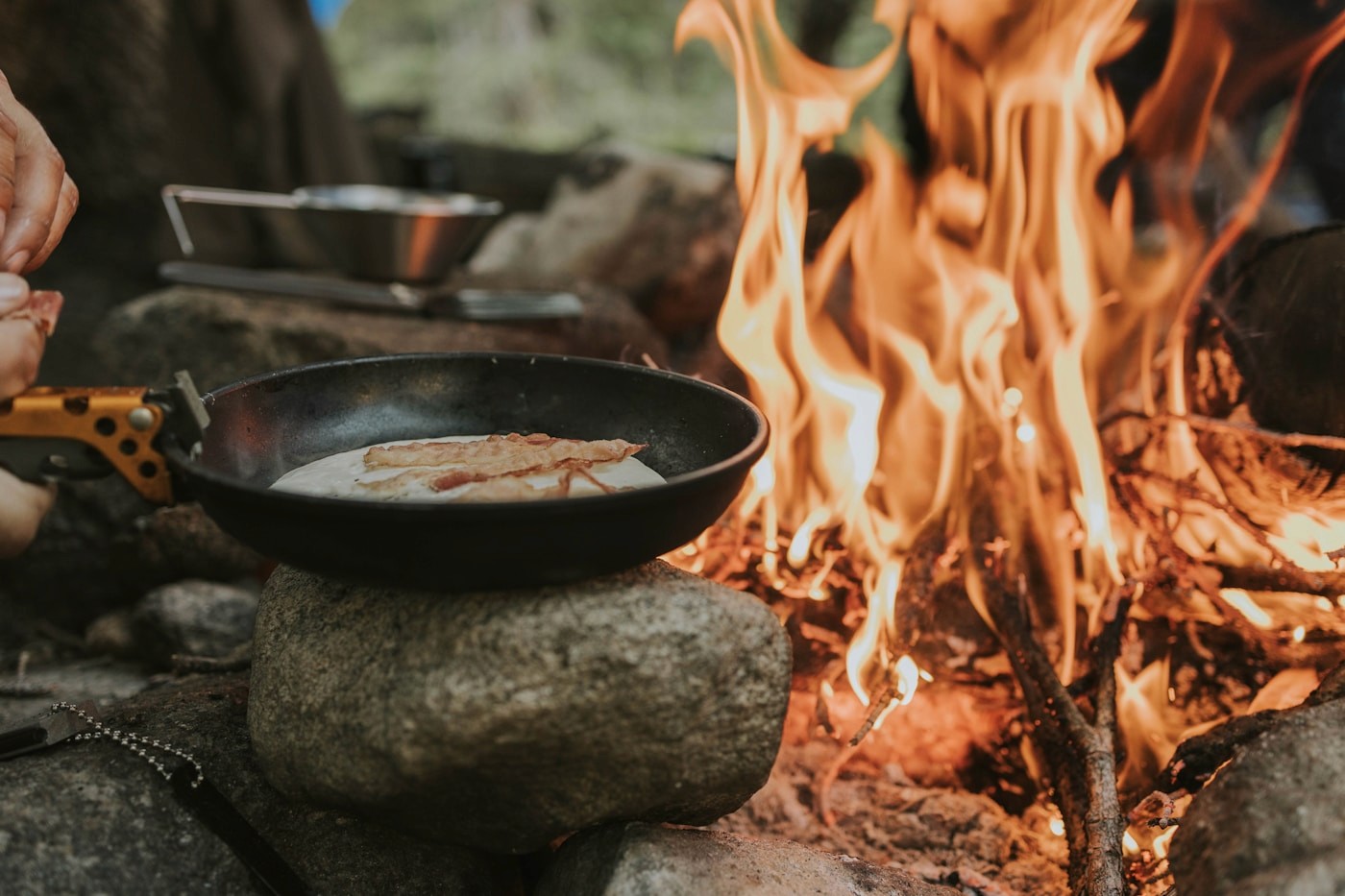 A chef cooking dinner over an open fire at a Namibian bush camp