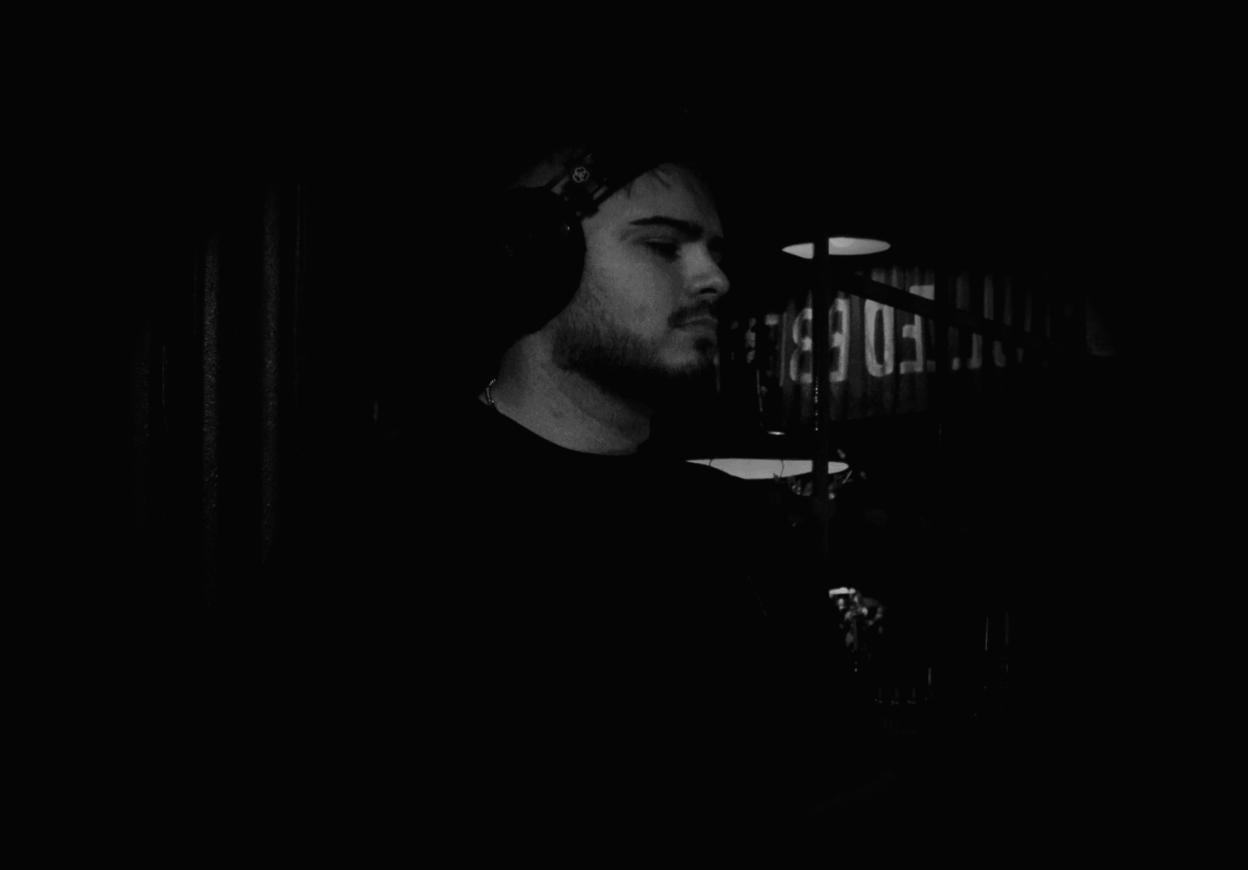 Felipe Ferreyra con auriculares foto en blanco y negro, tocando musica en posicion de perfil