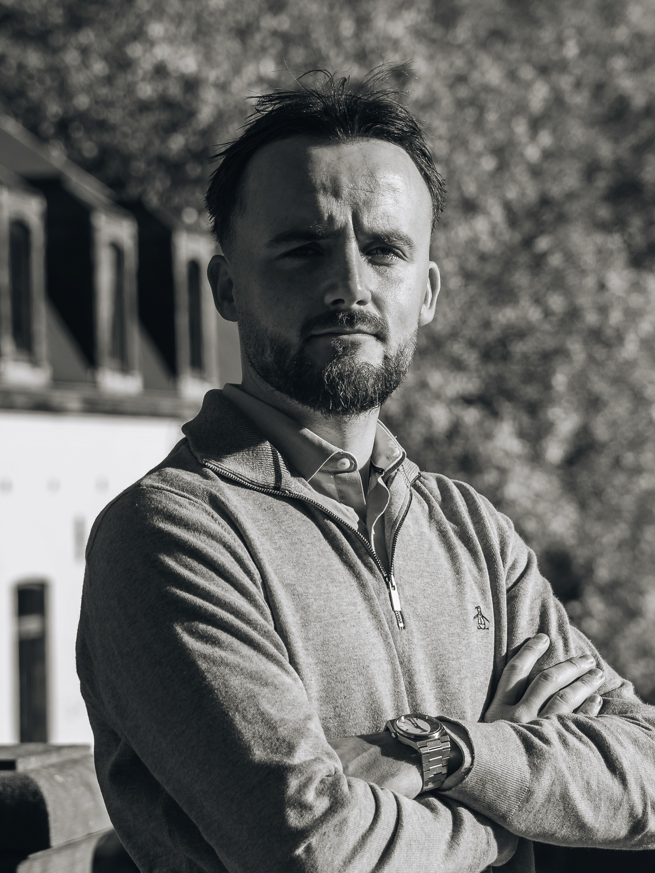 Portrait of a laughing person with curly hair wearing a white shirt