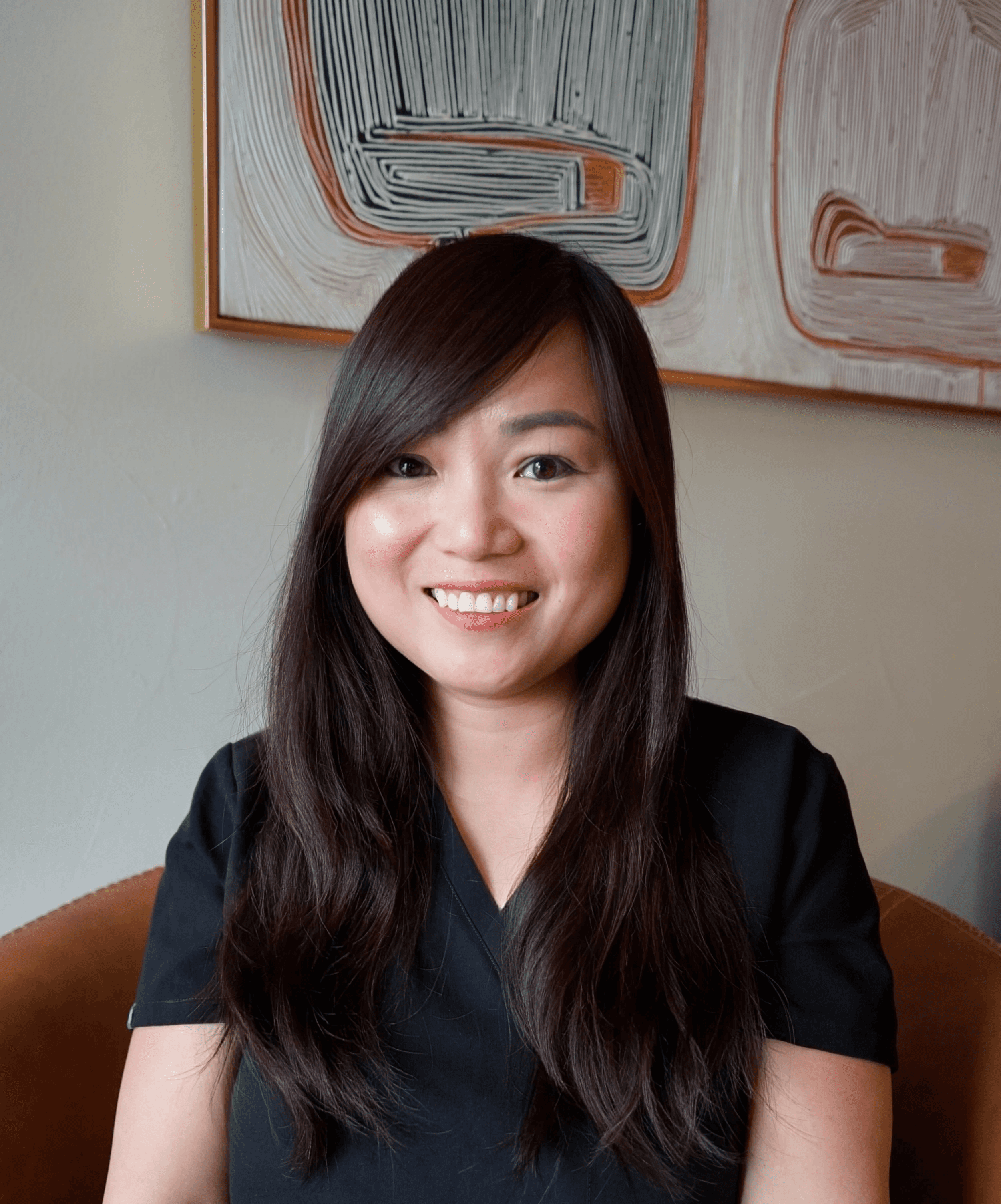 Anna Nguyen in leather chair with cowboy painting in background