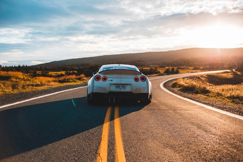 Detailed sports car on a scenic road at sunset